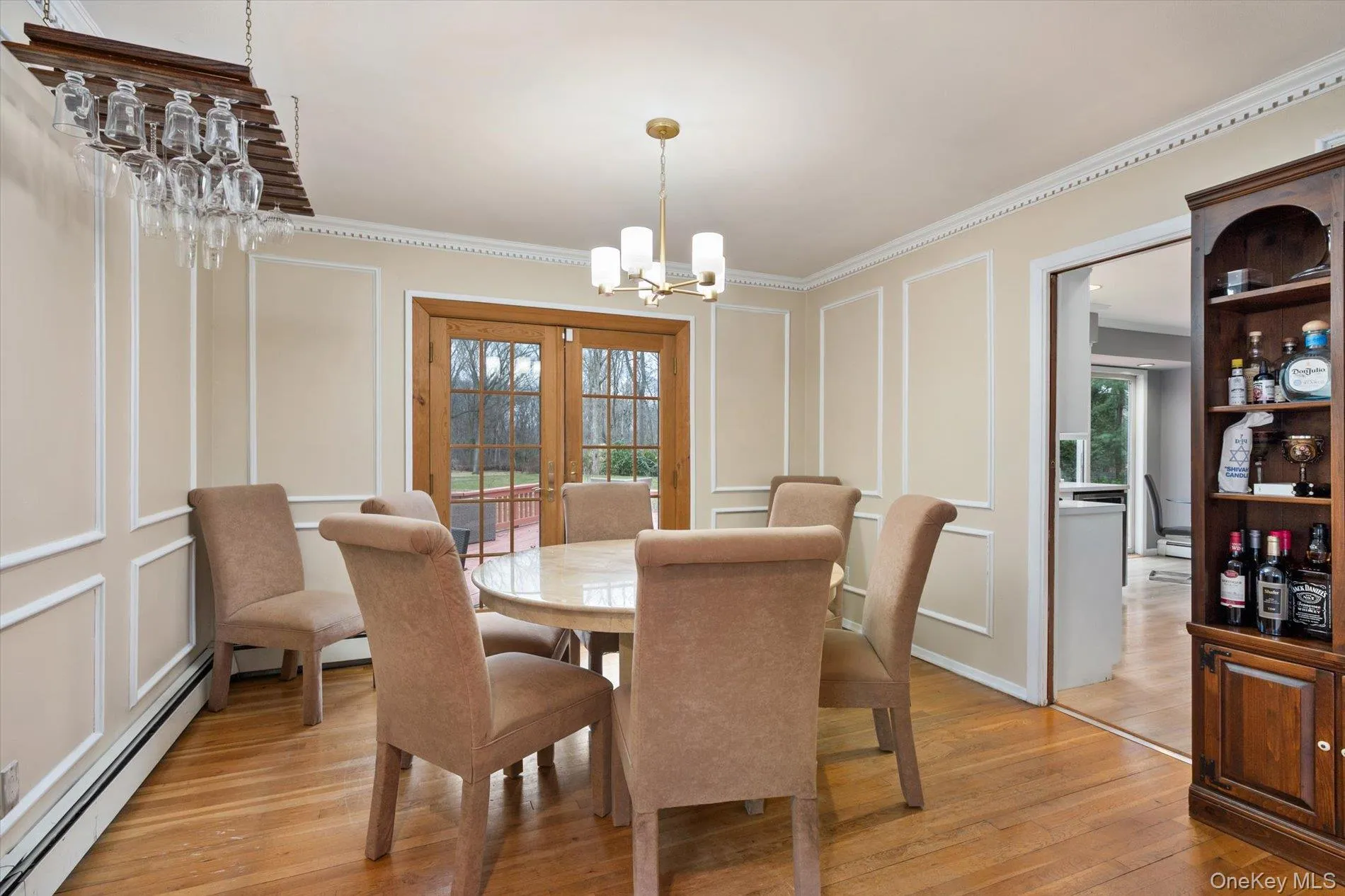 Dining room featuring a decorative wall, a baseboard heating unit, suspended lighting, wood-type flooring, and french doors Dining room featuring a decorative wall, a baseboard heating unit, suspended lighting, wood-type flooring, and french doors