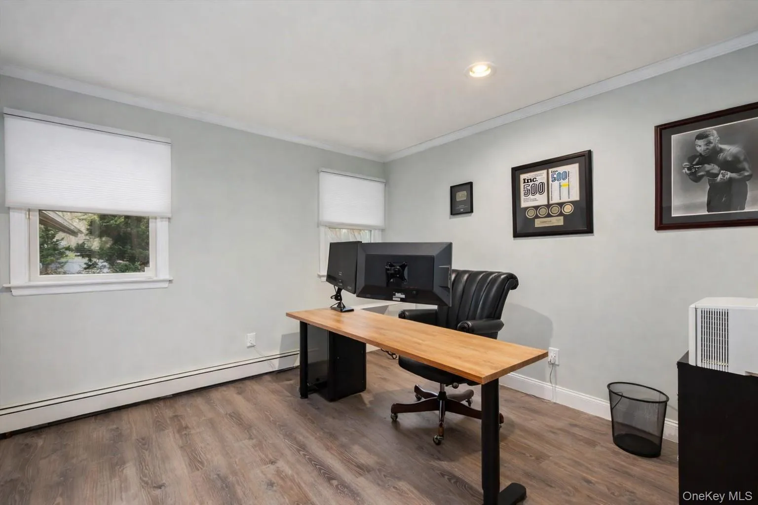 Office space featuring wood finished floors, ornamental molding, a baseboard heating unit, and recessed lighting Office space featuring wood finished floors, ornamental molding, a baseboard heating unit, and recessed lighting