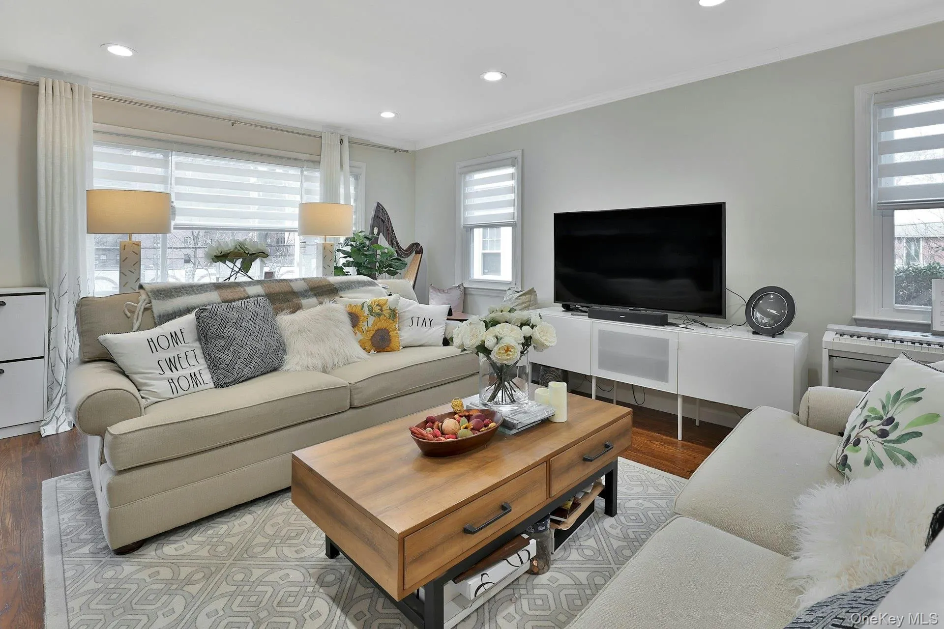 Living room featuring ornamental molding and light hardwood / wood-style floors Living room featuring ornamental molding and light hardwood / wood-style floors