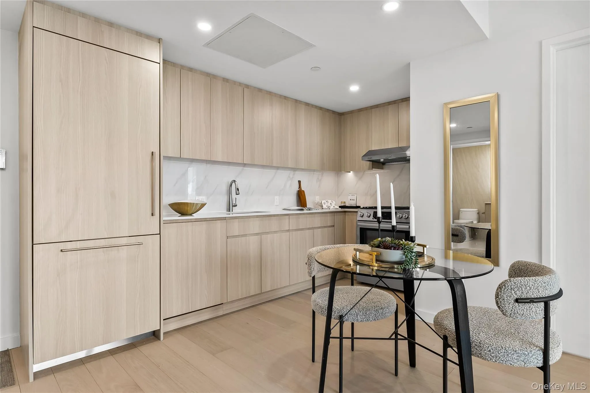 Kitchen with modern cabinets, light brown cabinets, light wood-style floors, stainless steel range, and recessed lighting Kitchen with modern cabinets, light brown cabinets, light wood-style floors, stainless steel range, and recessed lighting