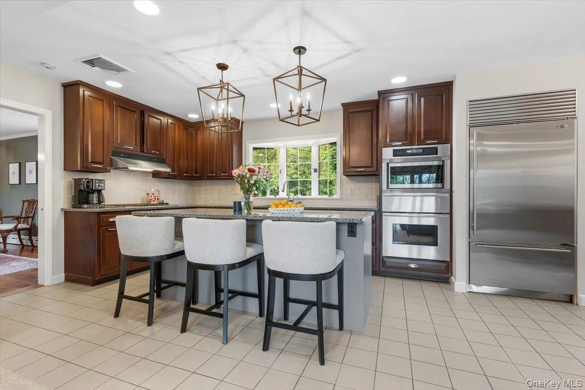 The renovated Chef's kitchen boasts two-tone cabinetry, granite counters, a greenhouse window, pendants over the center island/breakfast bar, stainless steel appliances including a SubZero Refrigerator & a 5 burner gas stove top which vents outside. The renovated Chef's kitchen boasts two-tone cabinetry, granite counters, a greenhouse window, pendants over the center island/breakfast bar, stainless steel appliances including a SubZero Refrigerator & a 5 burner gas stove top which vents outside.