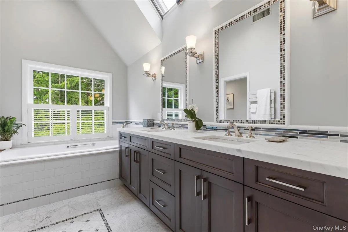 The marble Primary Bathroom was redone in 2015 with two heated towel racks, plantation shutters & a skylight over the Kohler soaking tub. The marble Primary Bathroom was redone in 2015 with two heated towel racks, plantation shutters & a skylight over the Kohler soaking tub.