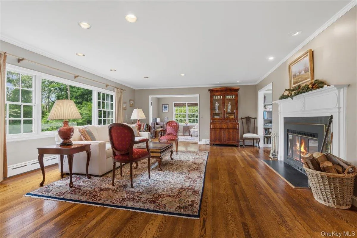The spacious Living Room offers beautiful views of nature, shiny oak floors, recessed lights and a wood-burning fireplace, as well as a reading nook with built-in shelves. The spacious Living Room offers beautiful views of nature, shiny oak floors, recessed lights and a wood-burning fireplace, as well as a reading nook with built-in shelves.