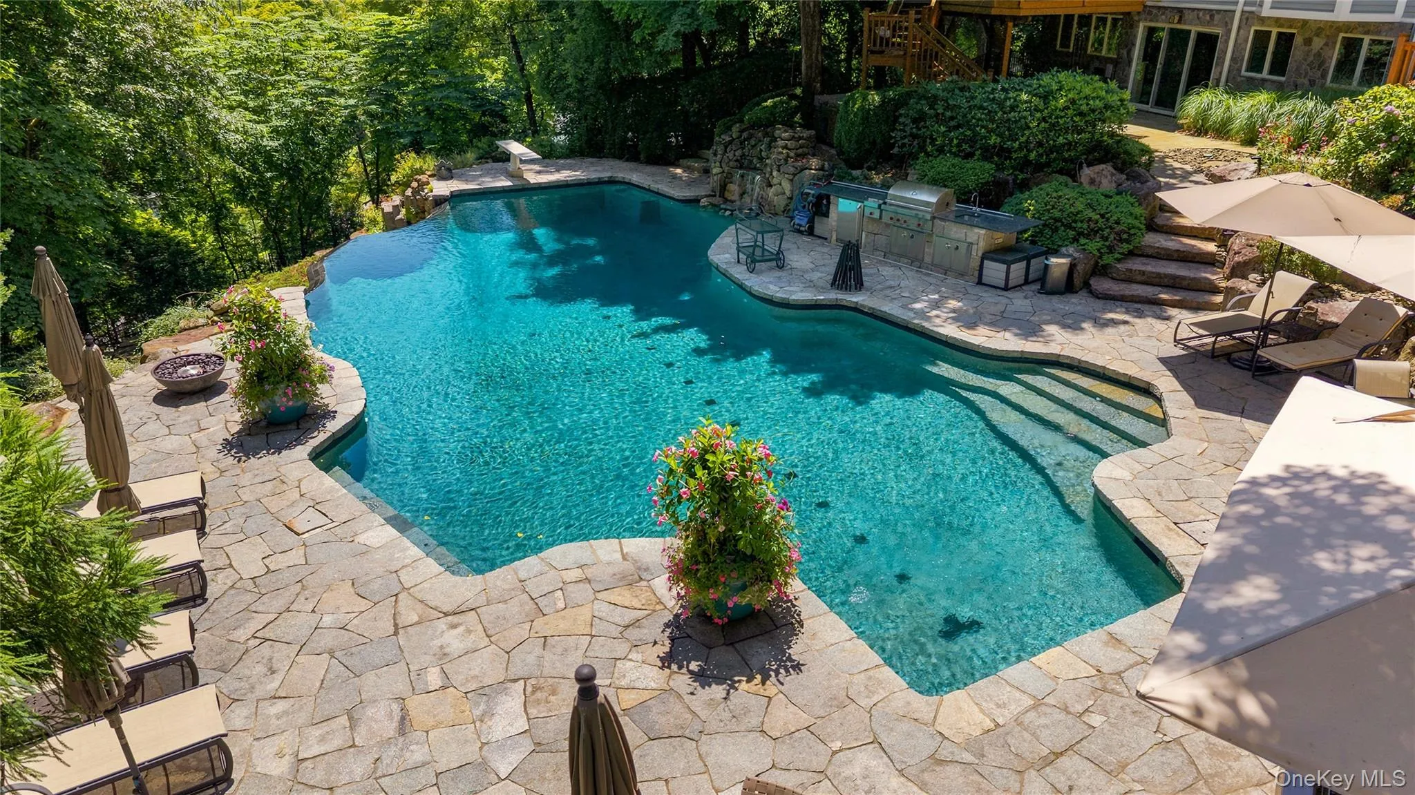 Luxurious free-form pool with no chemicals and surrounded by gorgeous patio with built-in outdoor kitchen, firepit and hot tub. Luxurious free-form pool with no chemicals and surrounded by gorgeous patio with built-in outdoor kitchen, firepit and hot tub.