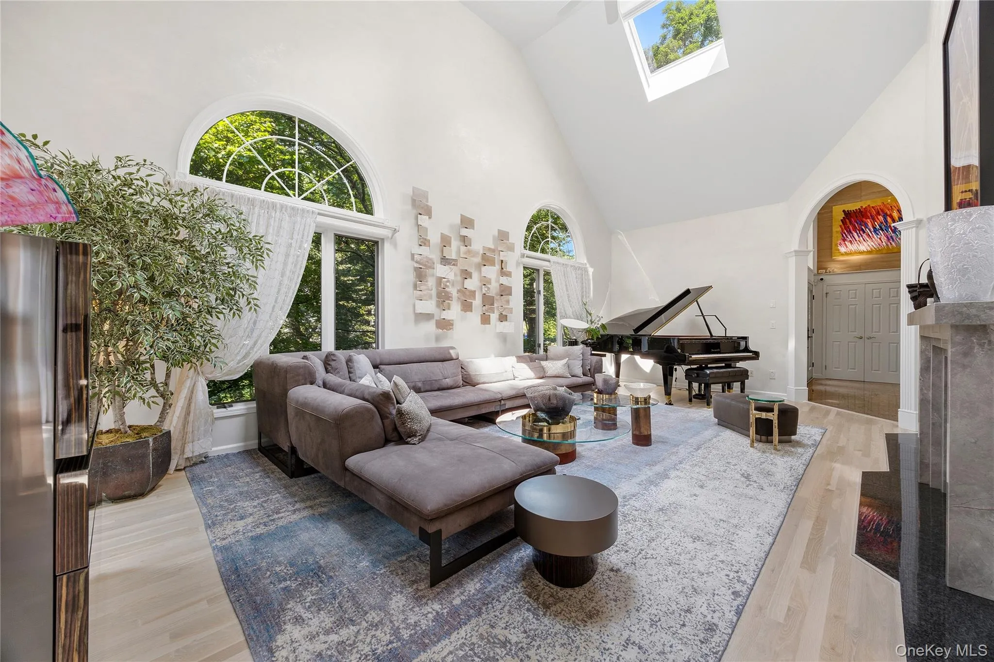 Bright Living Room with arched entry, hardwood flooring, recessed lights, two skylights, ceiling fan, B/I cabinets, wood burning Fireplace with granite floor and marble surround Bright Living Room with arched entry, hardwood flooring, recessed lights, two skylights, ceiling fan, B/I cabinets, wood burning Fireplace with granite floor and marble surround