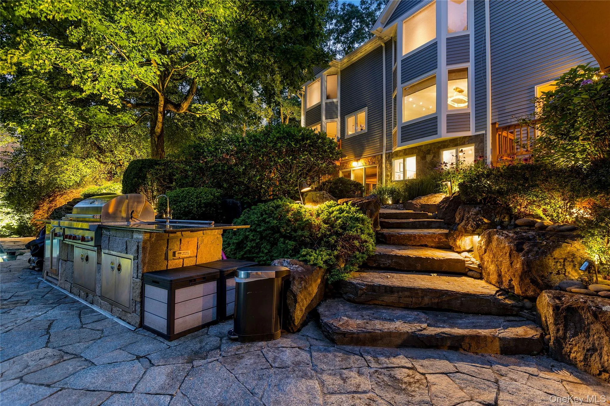 Close-up of the outdoor Kitchen at twilight, with natural stone steps from lower patio to upper patio Close-up of the outdoor Kitchen at twilight, with natural stone steps from lower patio to upper patio