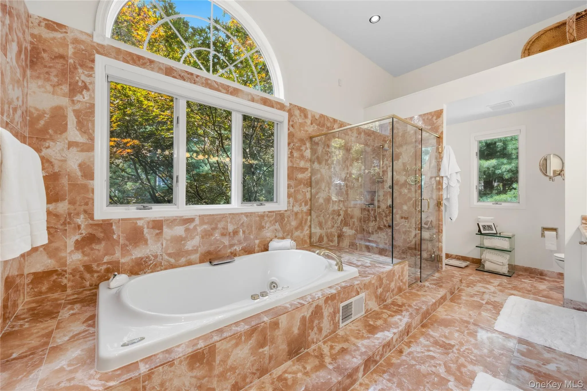 Primary Bathroom soaking tub with marble surround and nature views Primary Bathroom soaking tub with marble surround and nature views