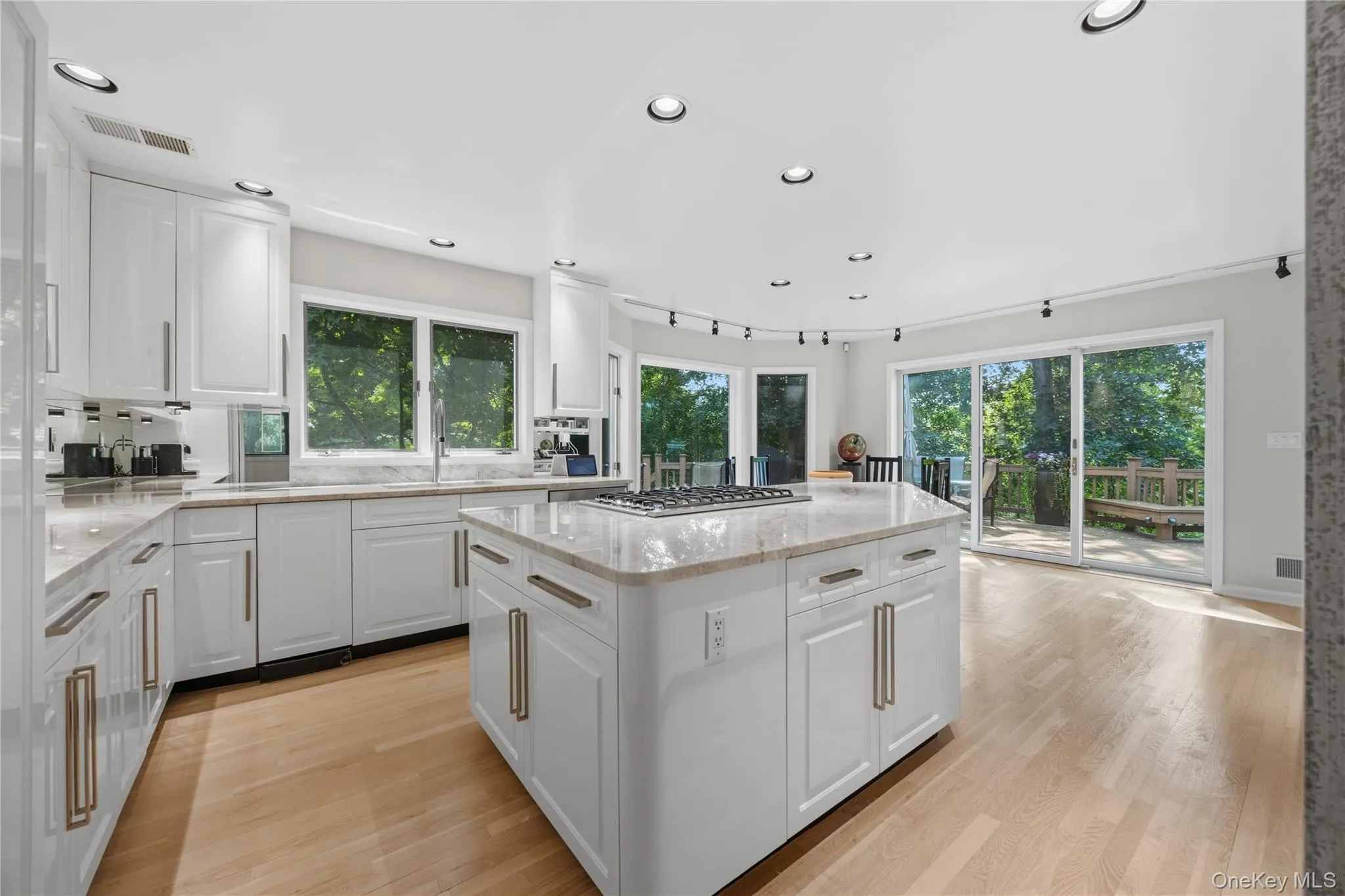 Eat-In-Kitchen with recessed lights, hardwood flooring, glass cabinets, quartzite counters, track lighting, sliding glass door to deck, B/I step stool for higher cabinets, pantry with pull outshelves, island with storage underneath and B/I eating table, Stainless Steel Appliances: Subzero Refrigerator, Bosch Dishwasher, Sharp B/I Microwave, Viking 6 burner gas stove, Monogram double wall oven Eat-In-Kitchen with recessed lights, hardwood flooring, glass cabinets, quartzite counters, track lighting, sliding glass door to deck, B/I step stool for higher cabinets, pantry with pull outshelves, island with storage underneath and B/I eating table, Stainless Steel Appliances: Subzero Refrigerator, Bosch Dishwasher, Sharp B/I Microwave, Viking 6 burner gas stove, Monogram double wall oven