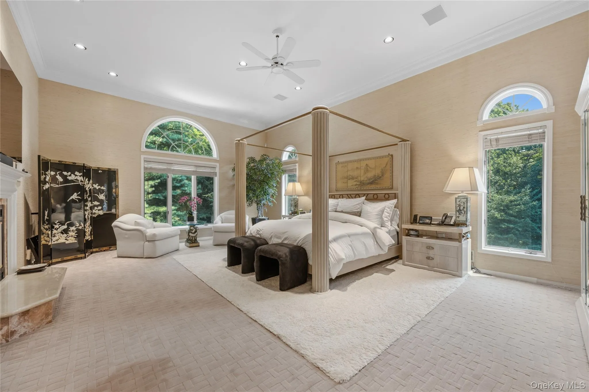 Breathtaking Primary Bedroom with arched entry, 3 large walk-in closets with track lighting with laundry chute, recessed lights, ceiling fan, B/I cabinets/drawers, double high ceiling, wood burning Fireplace with marble surround and custom wood mantle Breathtaking Primary Bedroom with arched entry, 3 large walk-in closets with track lighting with laundry chute, recessed lights, ceiling fan, B/I cabinets/drawers, double high ceiling, wood burning Fireplace with marble surround and custom wood mantle