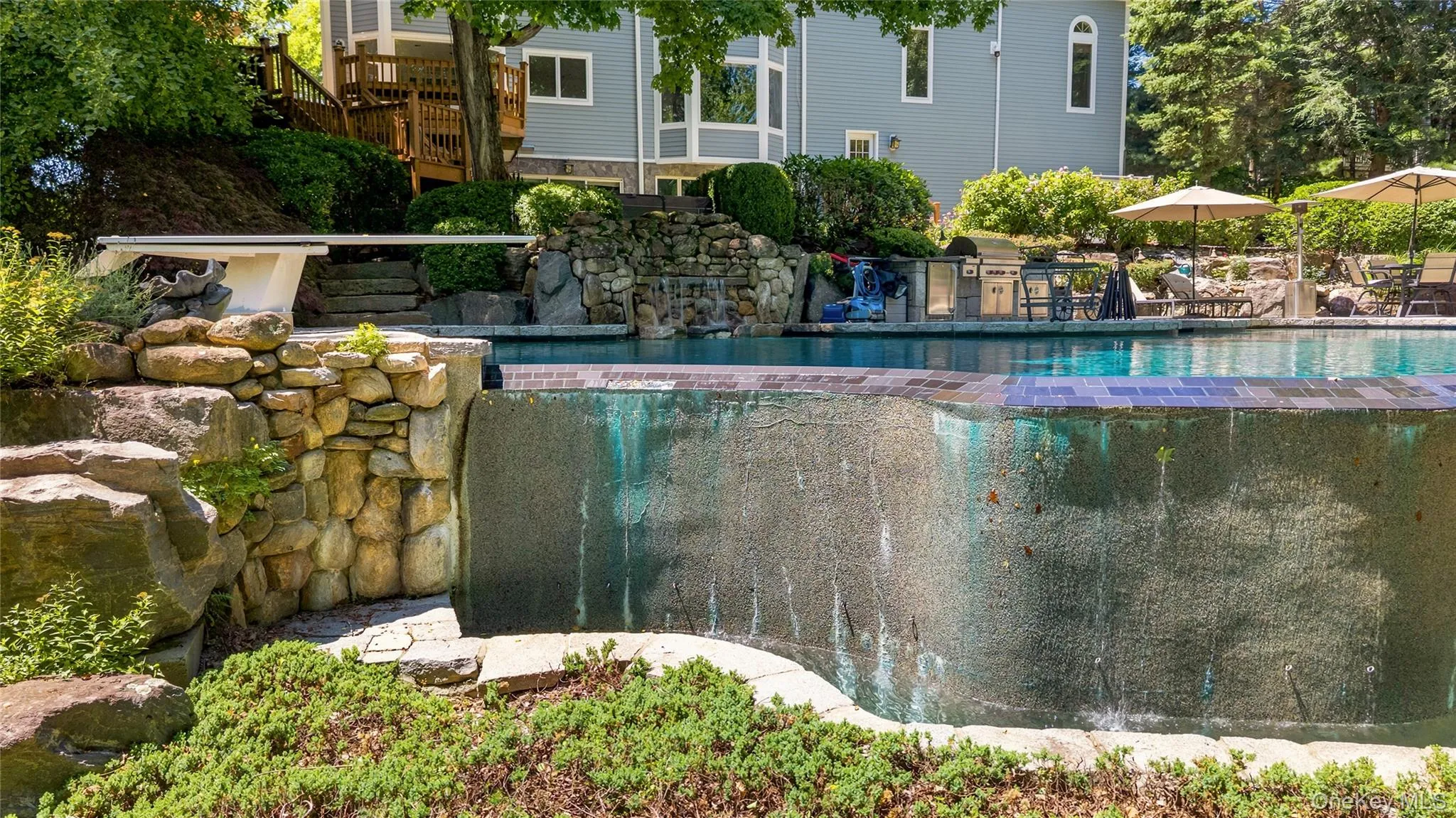 Infinity Edge of the free form pool with stone outcroppings Infinity Edge of the free form pool with stone outcroppings