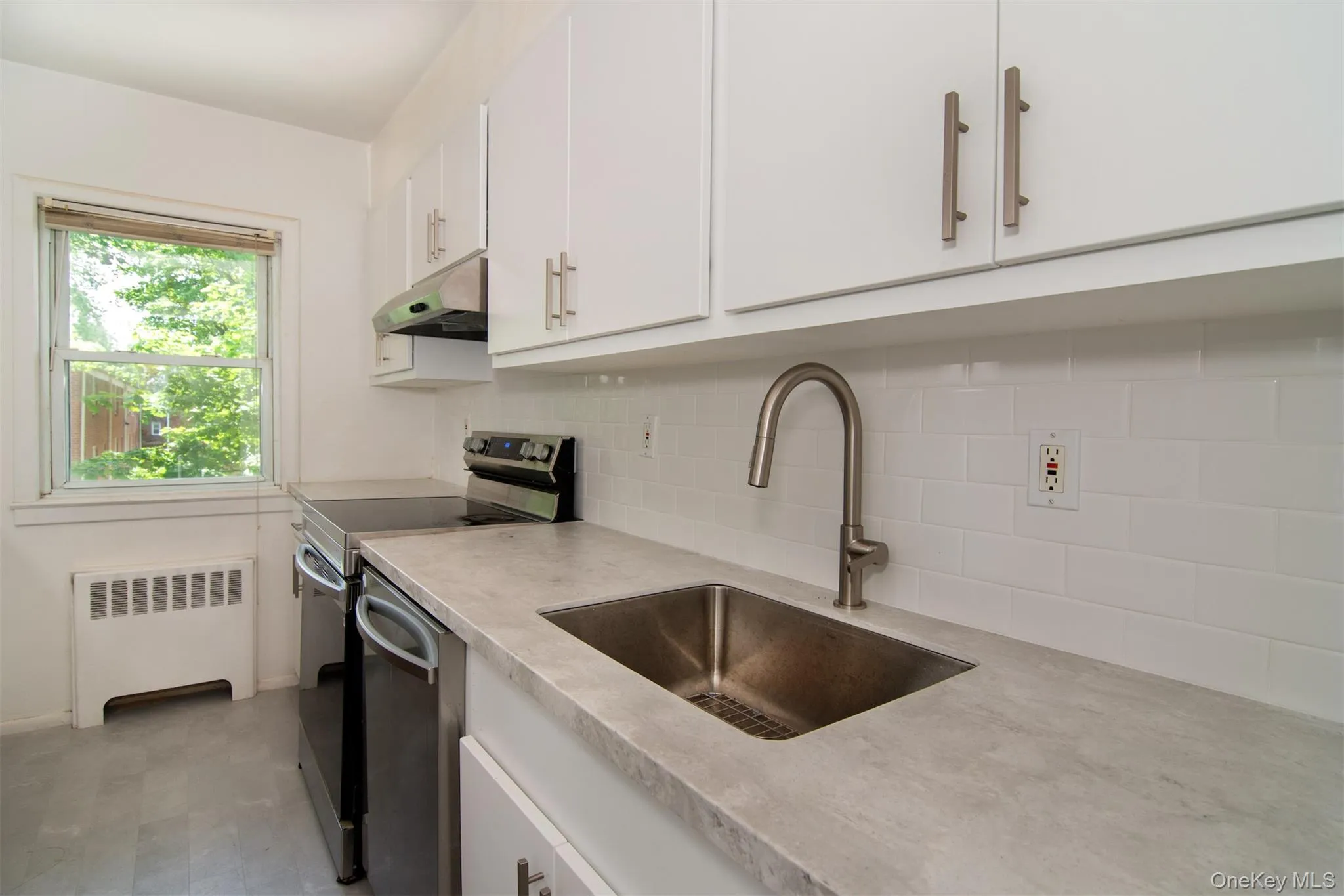 Kitchen with stainless steel appliances, deep sink, new cabinets, and tasteful backsplash Kitchen with stainless steel appliances, deep sink, new cabinets, and tasteful backsplash