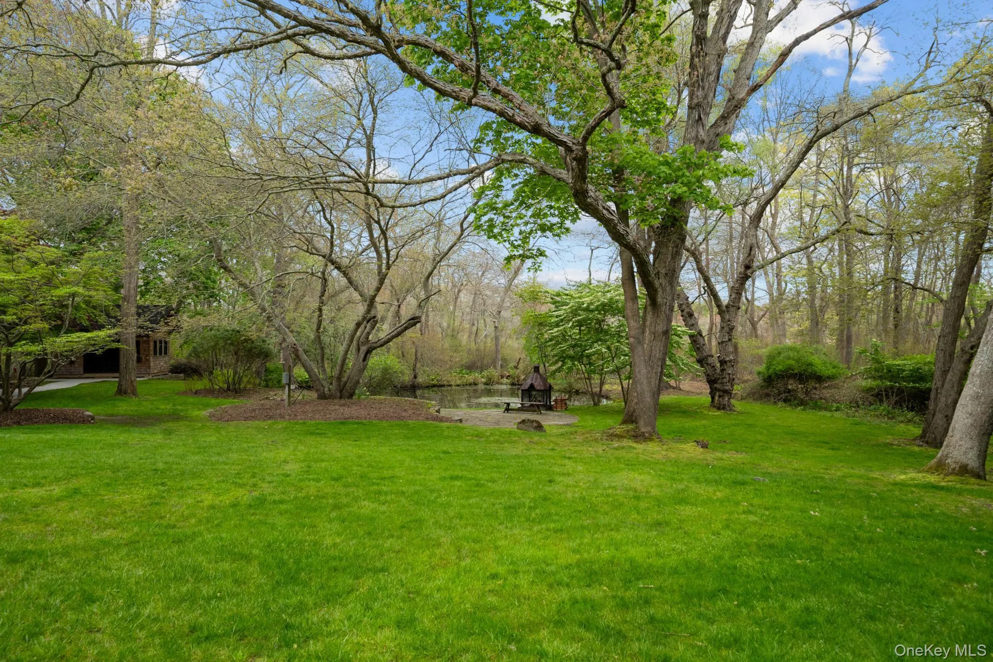Backyard with fire pit patio overlooking the pond Backyard with fire pit patio overlooking the pond