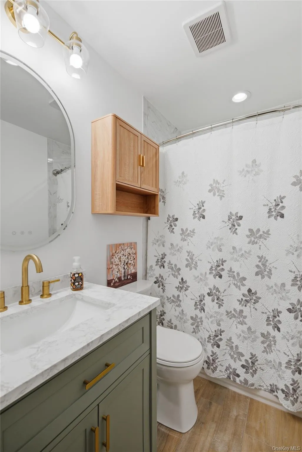 Vanity with a white countertop and integrated sink, gold-finish faucet, and olive green cabinetry Vanity with a white countertop and integrated sink, gold-finish faucet, and olive green cabinetry
