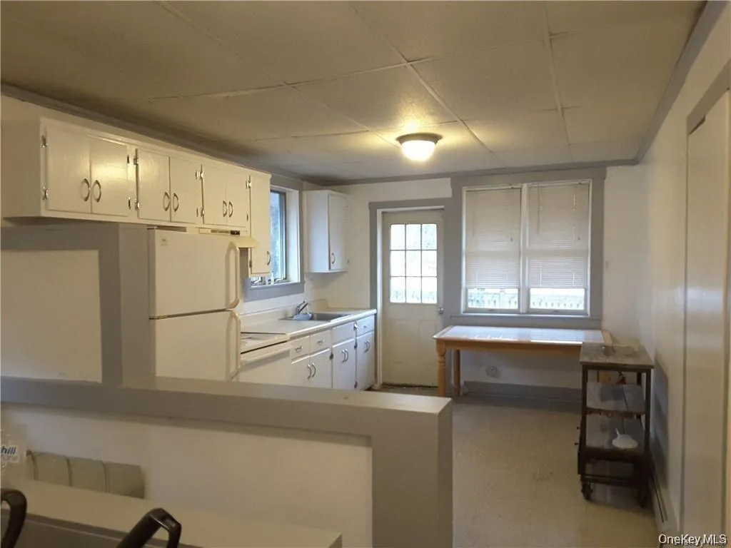 Compact kitchen with white cabinetry and integrated appliances Compact kitchen with white cabinetry and integrated appliances
