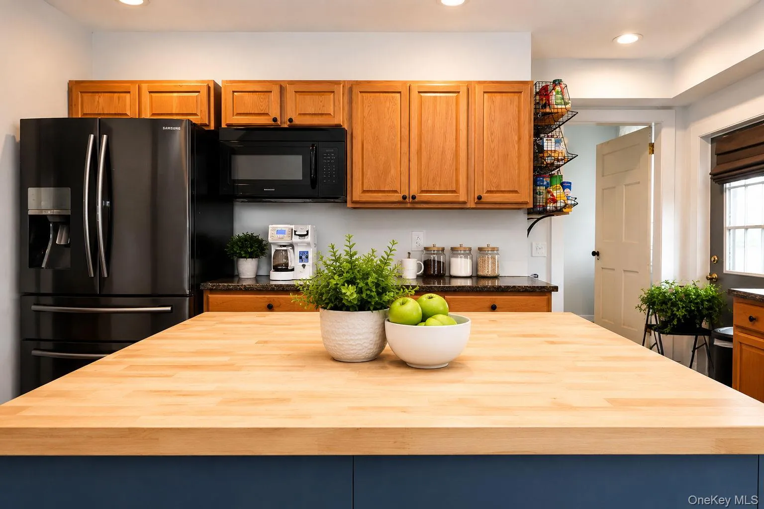 Black stainless steel double door refrigerator, microwave and wood cabinets Black stainless steel double door refrigerator, microwave and wood cabinets