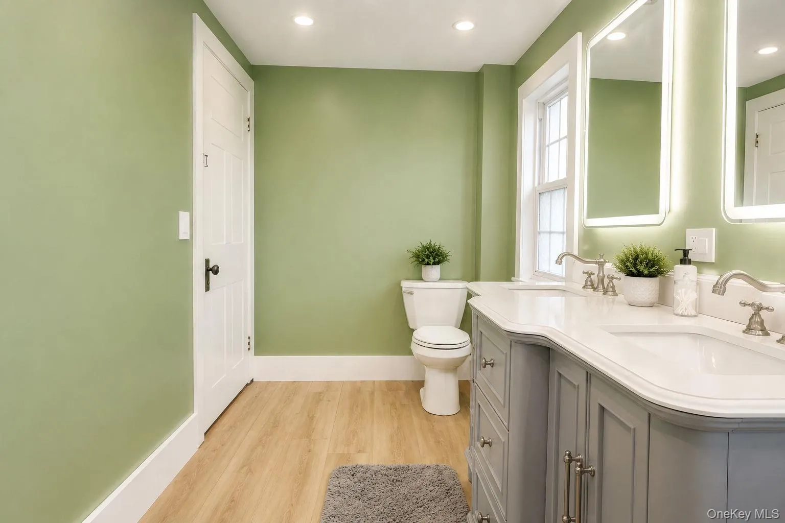 View of the double vanity and toilet with vinyl plank flooring View of the double vanity and toilet with vinyl plank flooring