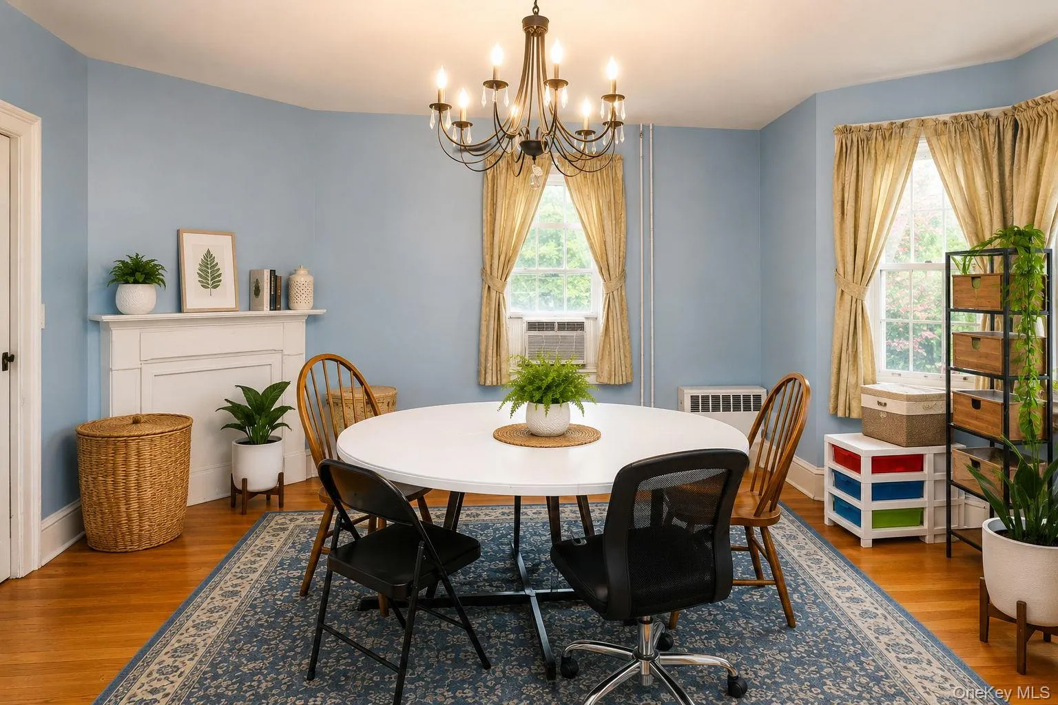 Formal dinning room with view of decorative wood mantel and wood floors and window ac unit Formal dinning room with view of decorative wood mantel and wood floors and window ac unit