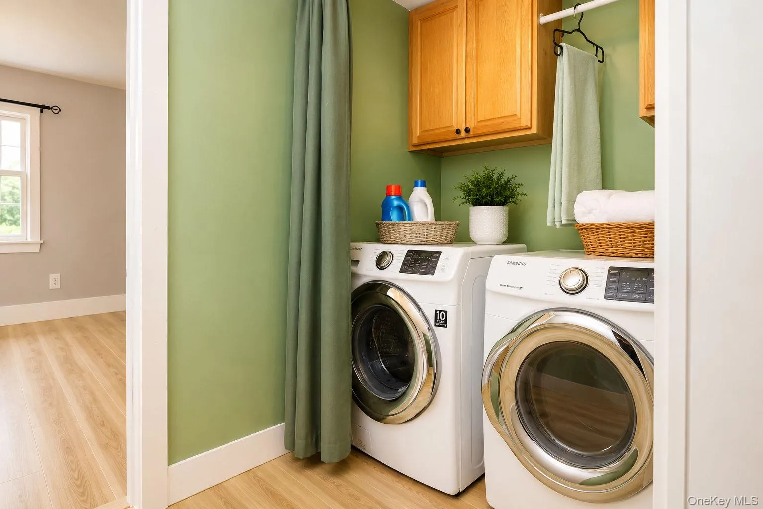 Laundry room with washer and dryer and extra cabinet space for storage with vinyl plan flooring Laundry room with washer and dryer and extra cabinet space for storage with vinyl plan flooring