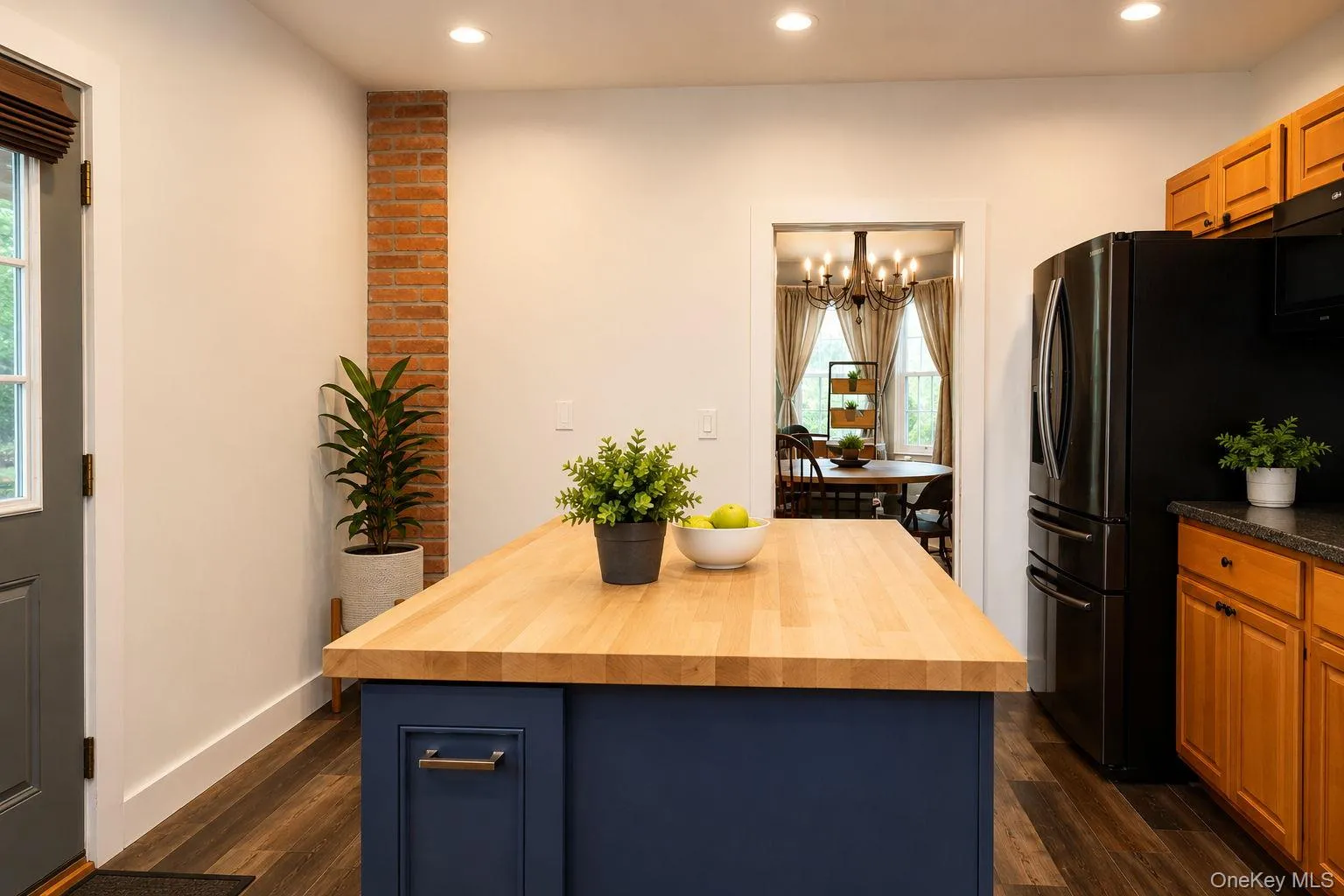 Butcher block island with view into the formal dinning room and wall features exposed brick Butcher block island with view into the formal dinning room and wall features exposed brick