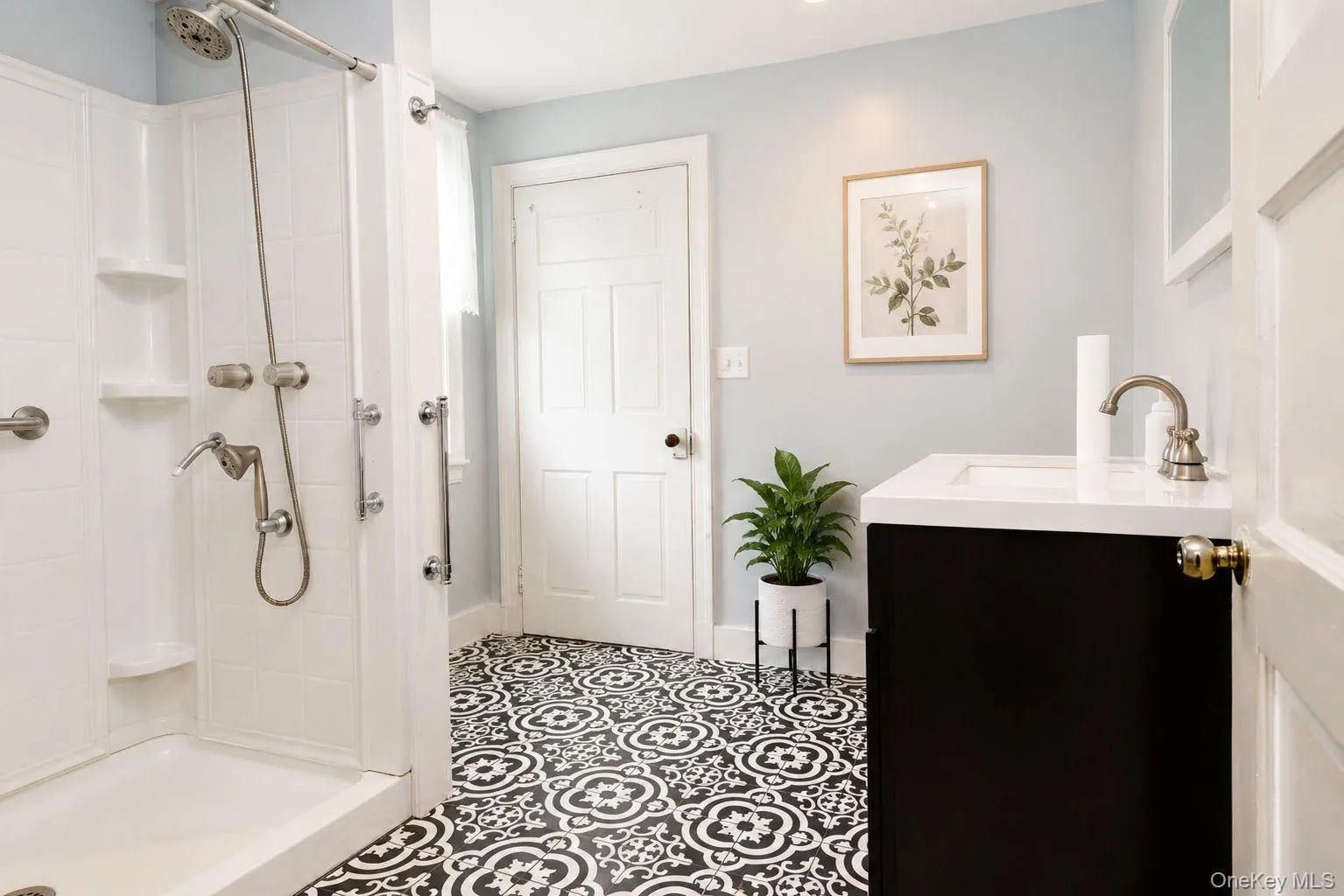 Updated bathroom on main level of the home with walk in shower, vanity and tile flooring Updated bathroom on main level of the home with walk in shower, vanity and tile flooring