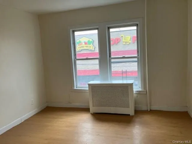 Spare room featuring radiator and light wood-style flooring Spare room featuring radiator and light wood-style flooring