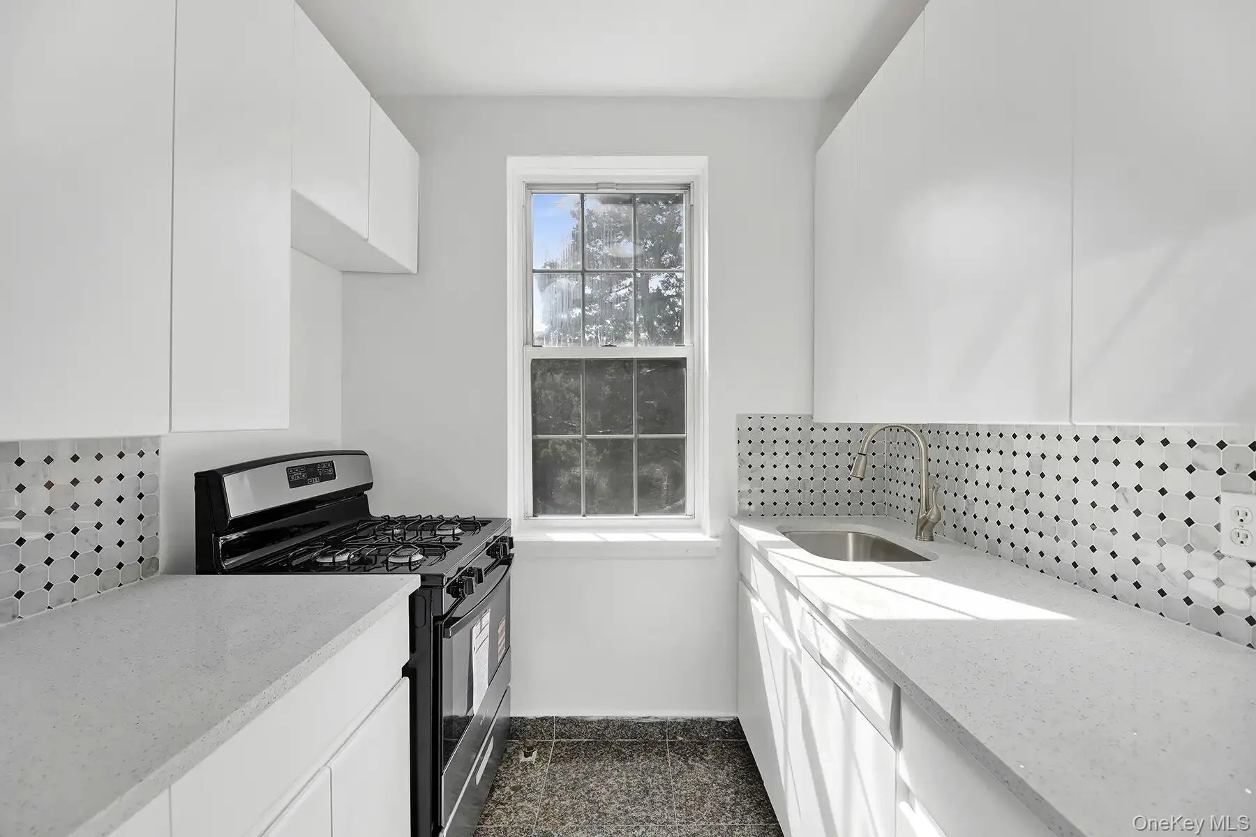 Galley kitchen featuring white cabinetry, light countertops, mosaic tile backsplash, stainless steel sink with gooseneck faucet, and a black and stainless steel range Galley kitchen featuring white cabinetry, light countertops, mosaic tile backsplash, stainless steel sink with gooseneck faucet, and a black and stainless steel range