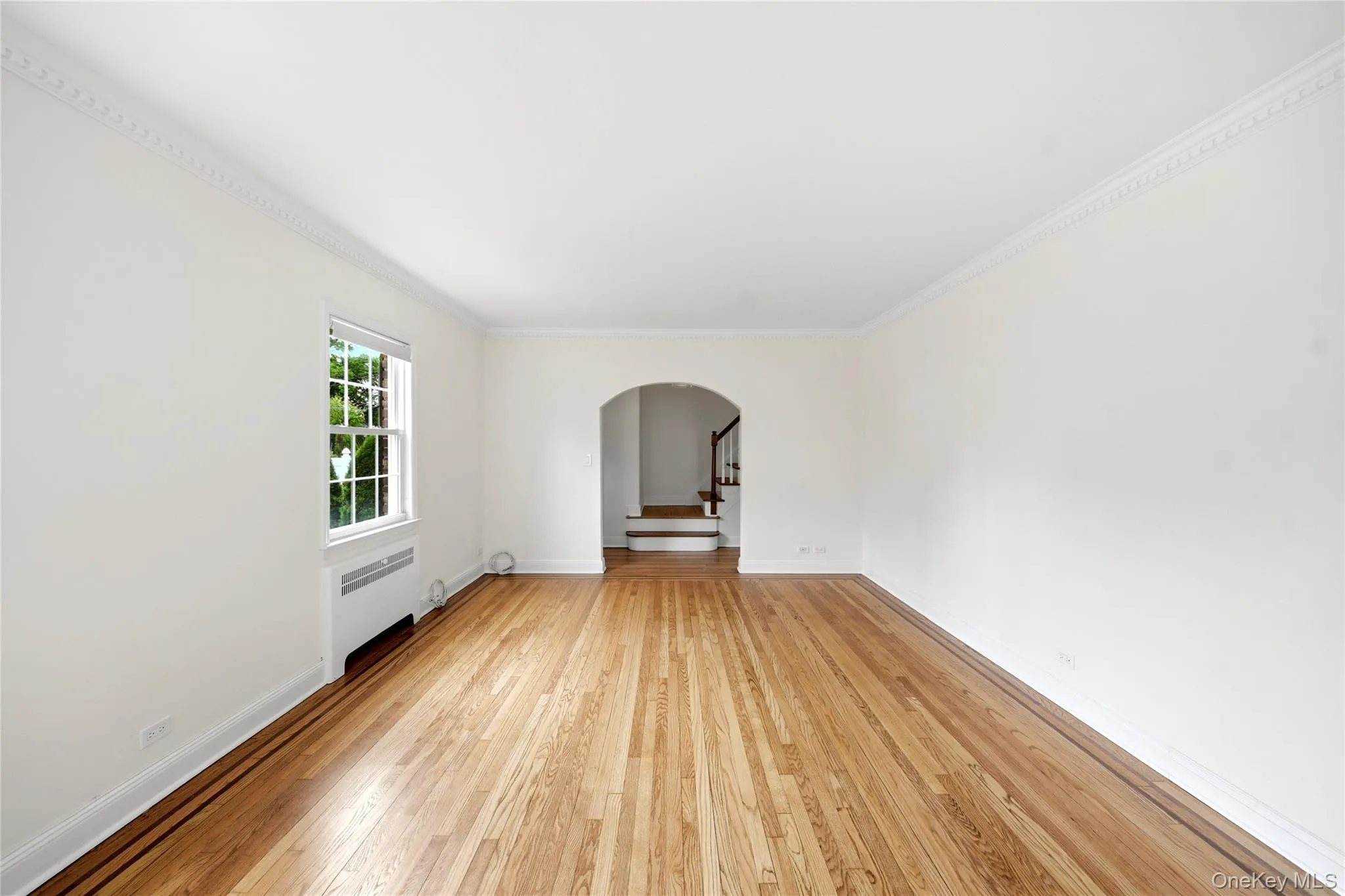 Living Room, features gleaming wood floors and arch to hallway Living Room, features gleaming wood floors and arch to hallway