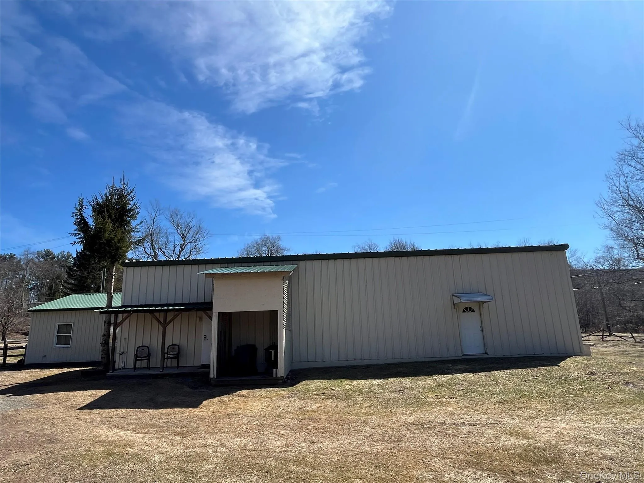 Metal-sided structure featuring a green metal roof and an attached covered porch Metal-sided structure featuring a green metal roof and an attached covered porch