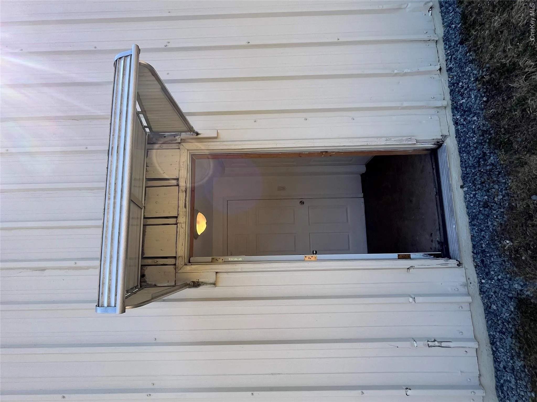 Corrugated metal exterior with an aluminum awning over an entry door Corrugated metal exterior with an aluminum awning over an entry door