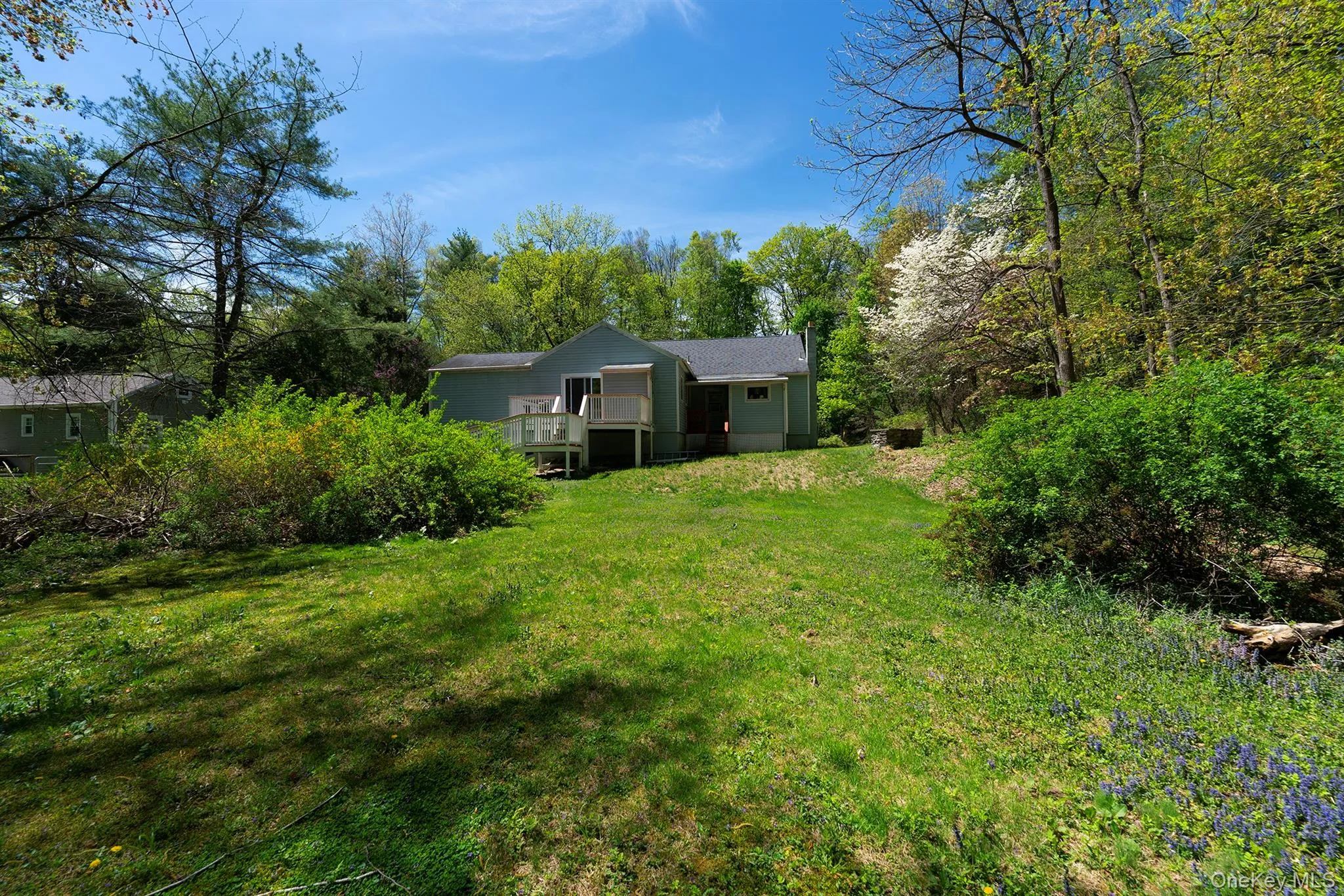 View of grassy yard with a wooden deck View of grassy yard with a wooden deck