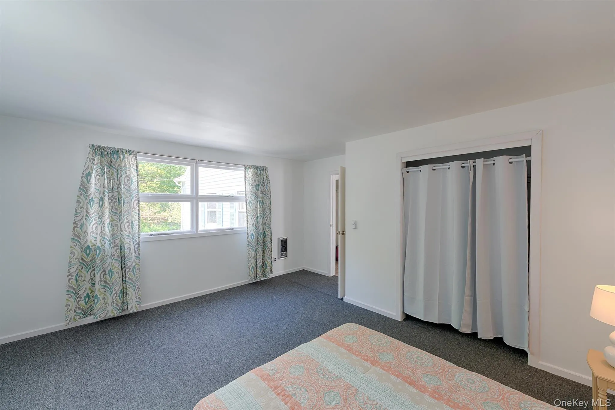 Bedroom with dark colored carpet and baseboards Bedroom with dark colored carpet and baseboards