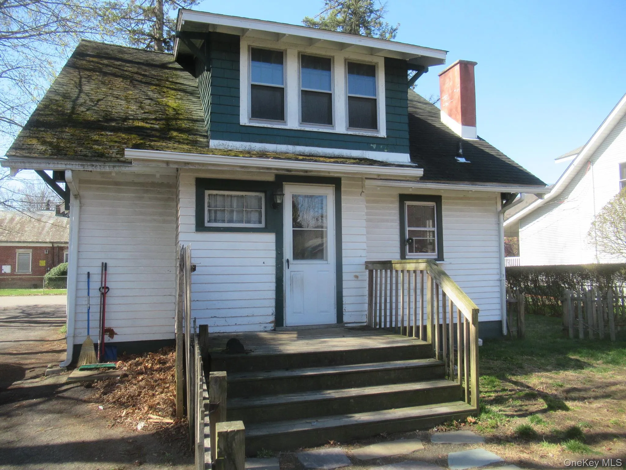White siding exterior with a dark green gabled dormer White siding exterior with a dark green gabled dormer