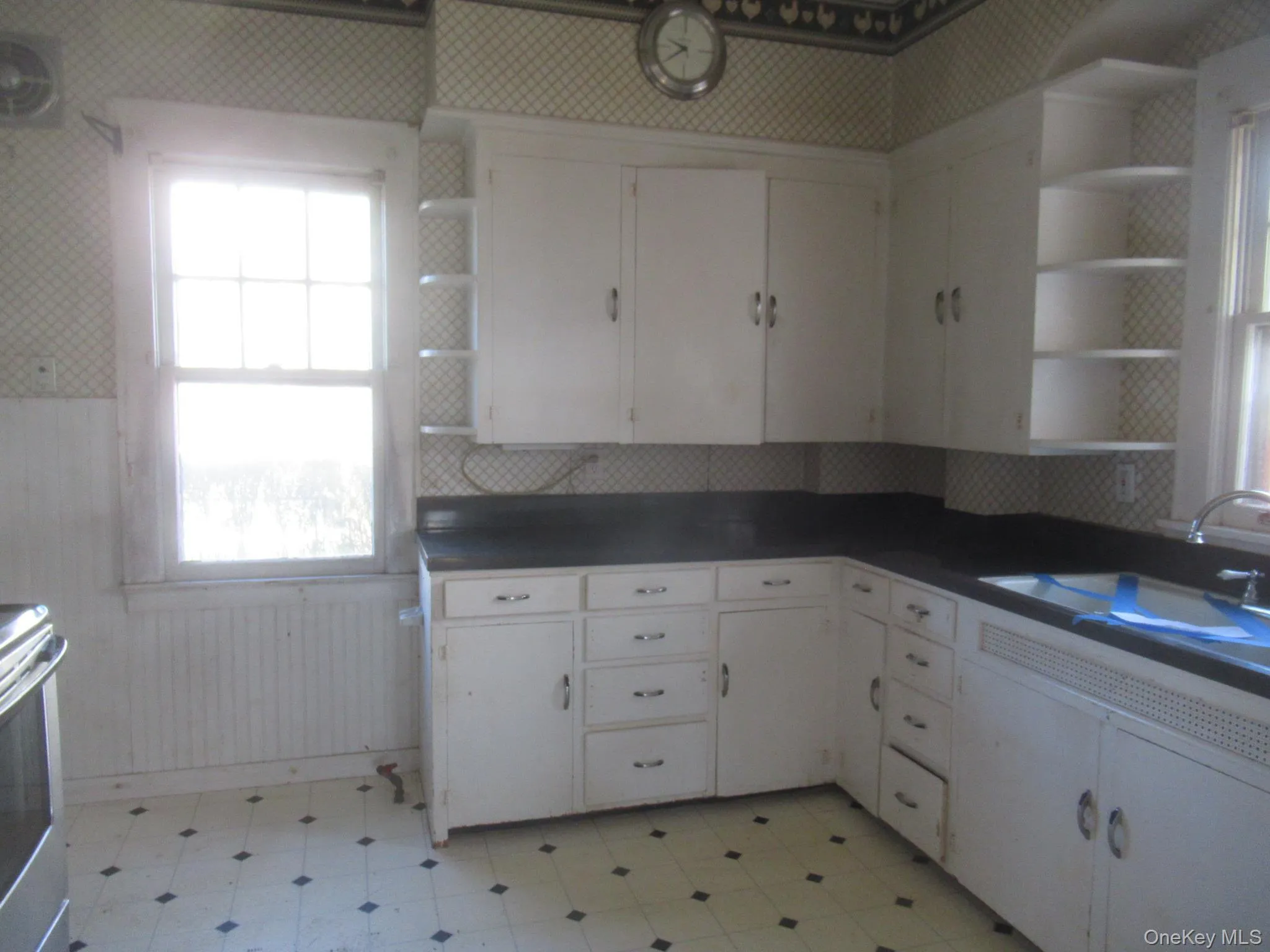 White cabinetry with dark countertops, built-in corner shelving White cabinetry with dark countertops, built-in corner shelving