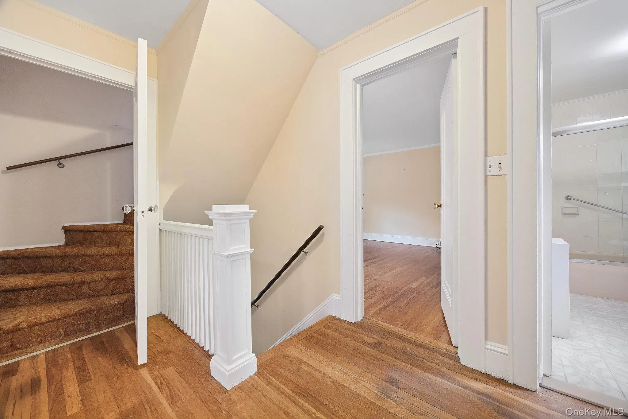 Stairway with wood finished floors and lofted ceiling Stairway with wood finished floors and lofted ceiling