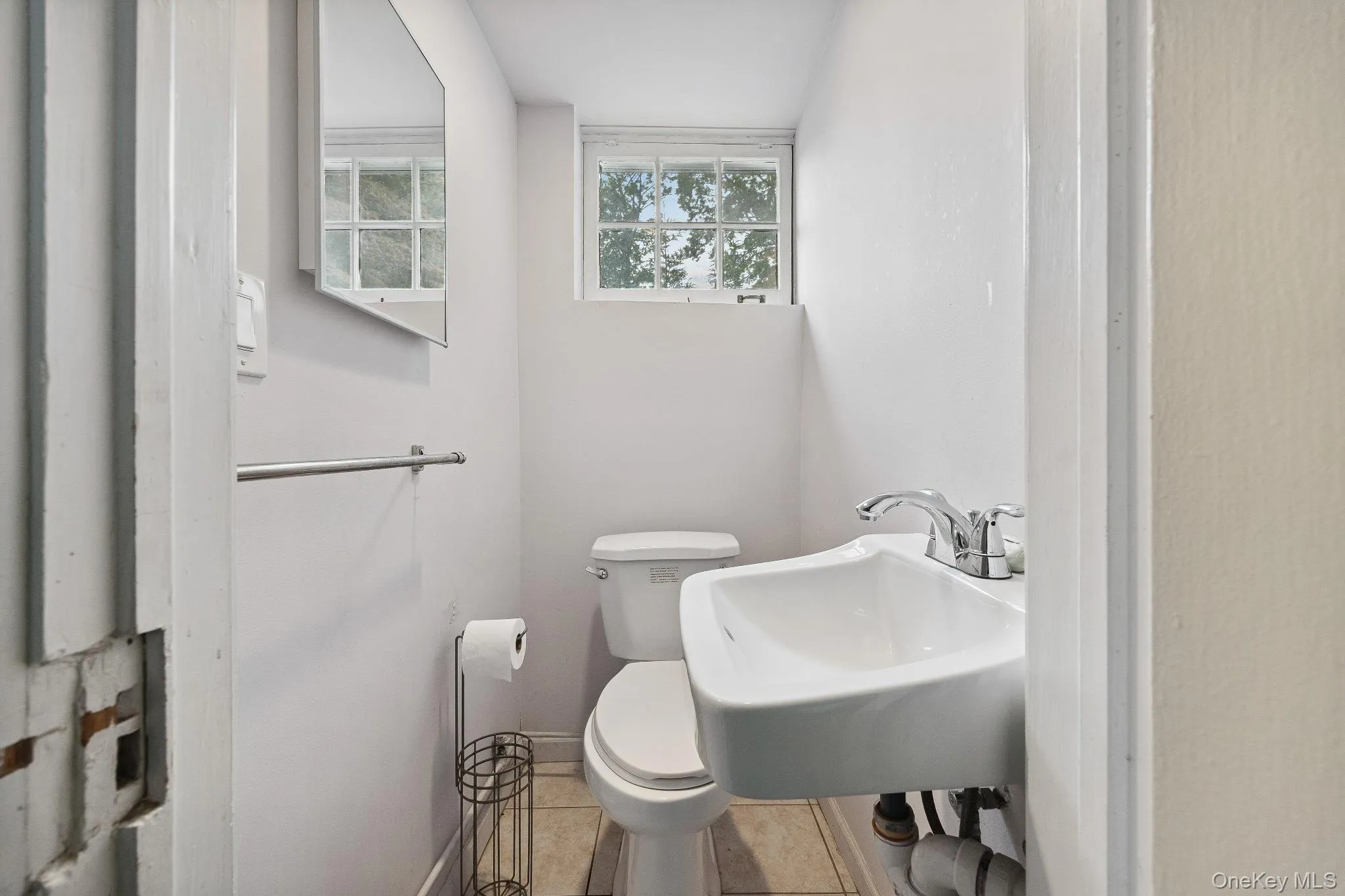 Half bathroom featuring toilet and tile patterned floors Half bathroom featuring toilet and tile patterned floors