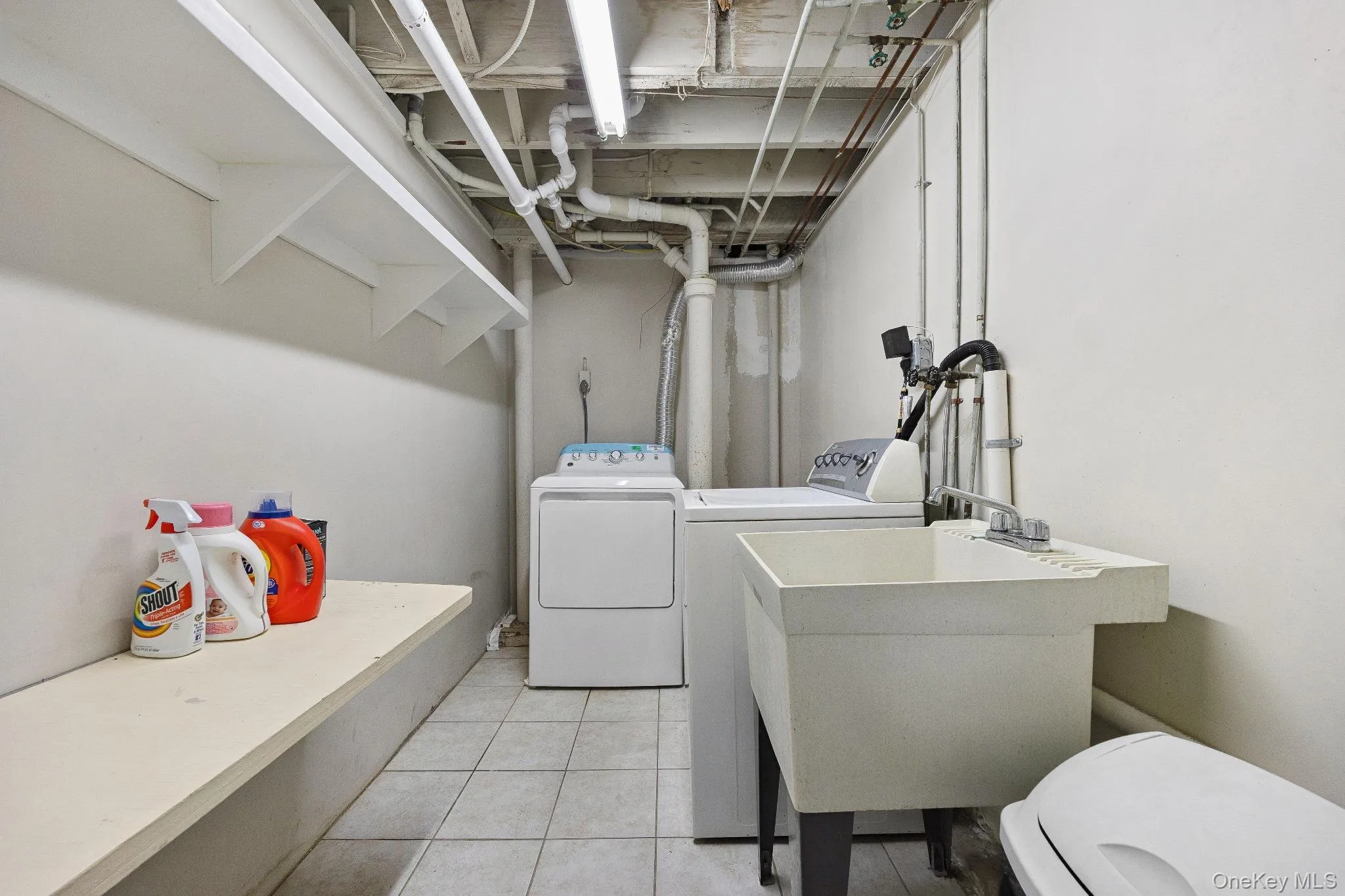 Washroom featuring independent washer and dryer and light tile patterned floors Washroom featuring independent washer and dryer and light tile patterned floors