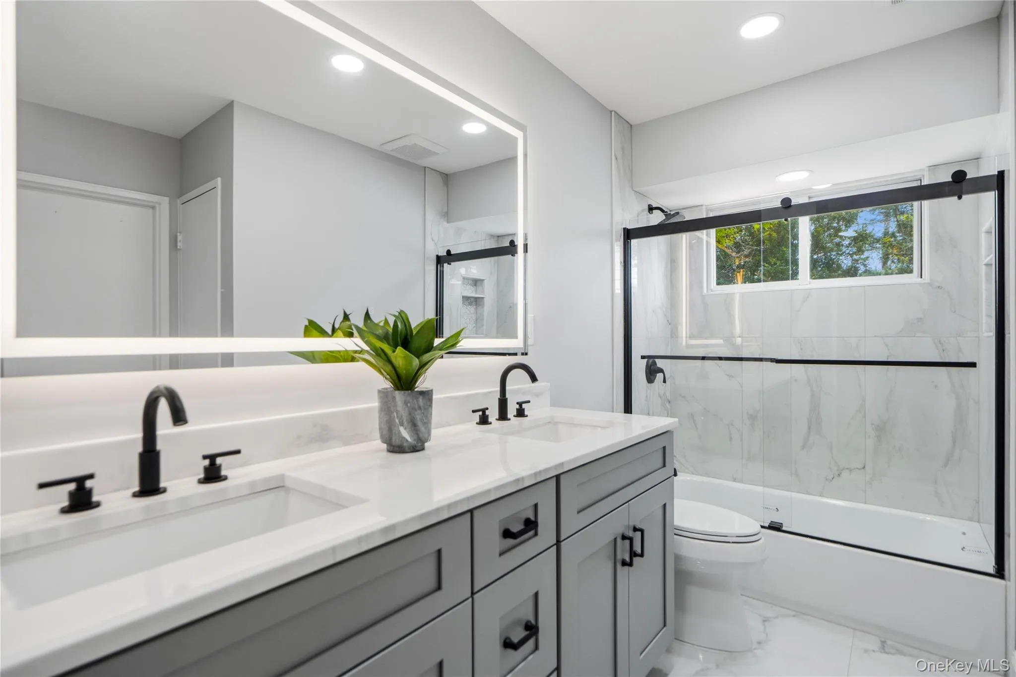 Modern bathroom featuring a double vanity with gray cabinetry and white quartz countertops Modern bathroom featuring a double vanity with gray cabinetry and white quartz countertops