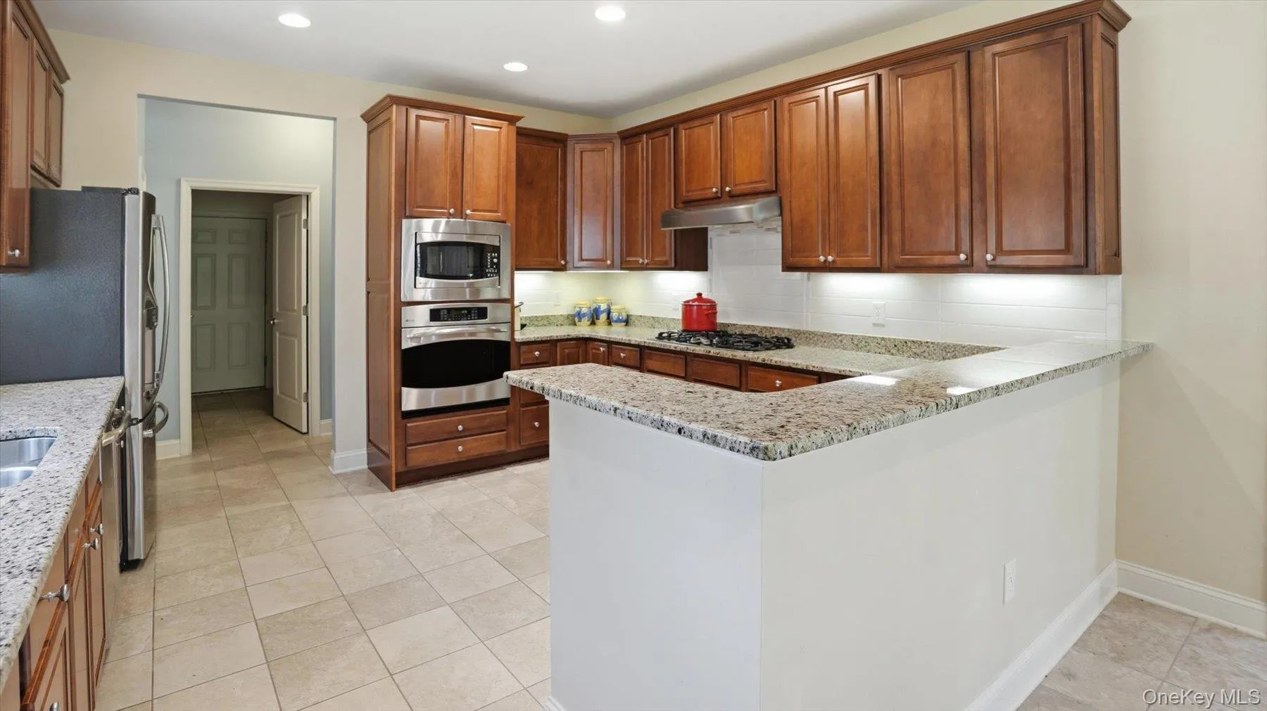 Gourmet kitchen featuring a large Eat-in-Counter, newer stainless steel refrigerator and tile flooring Gourmet kitchen featuring a large Eat-in-Counter, newer stainless steel refrigerator and tile flooring
