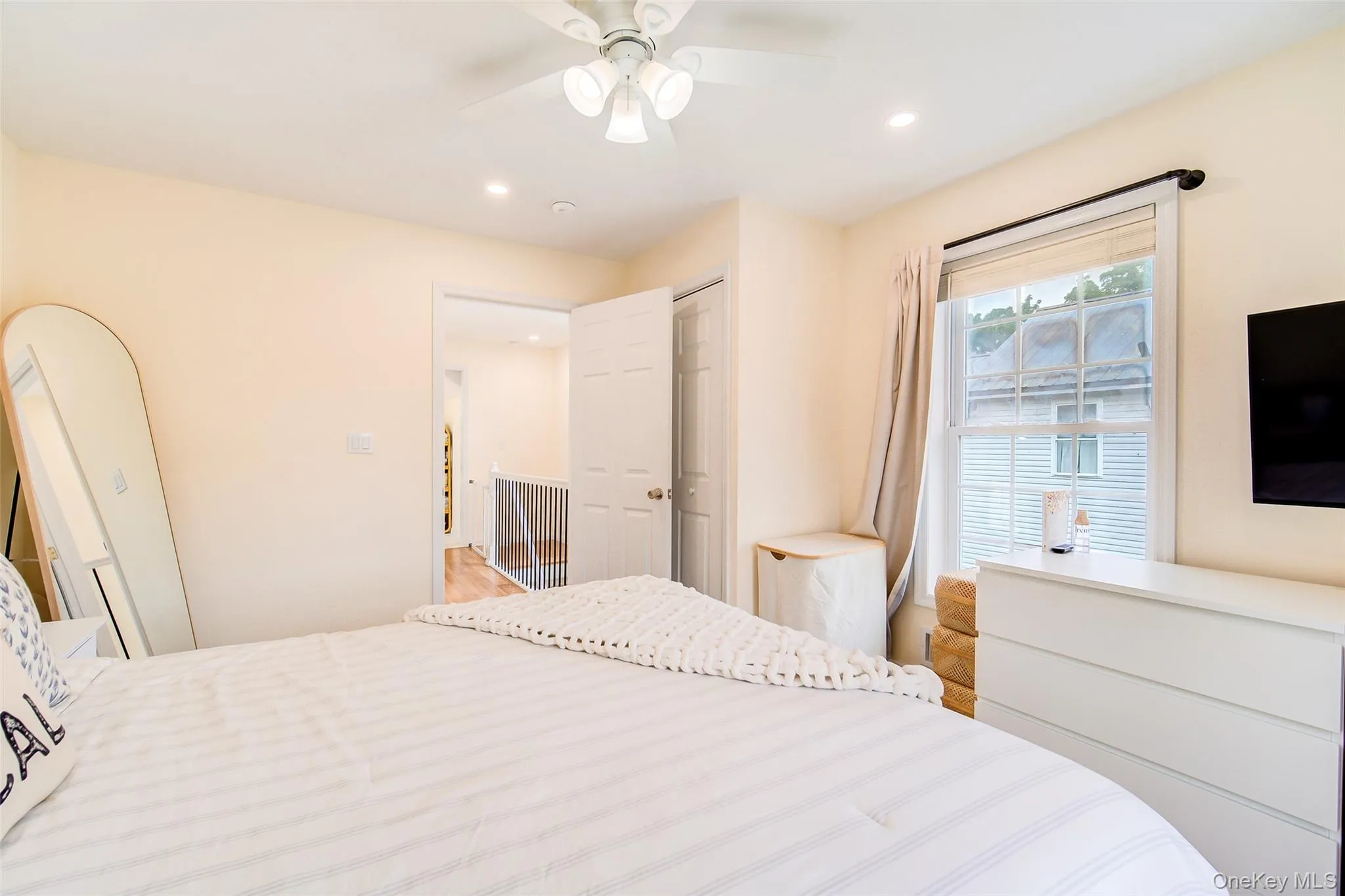 Master bedroom featuring a ceiling fan with integrated lighting, recessed lighting, and a single window with a white frame Master bedroom featuring a ceiling fan with integrated lighting, recessed lighting, and a single window with a white frame