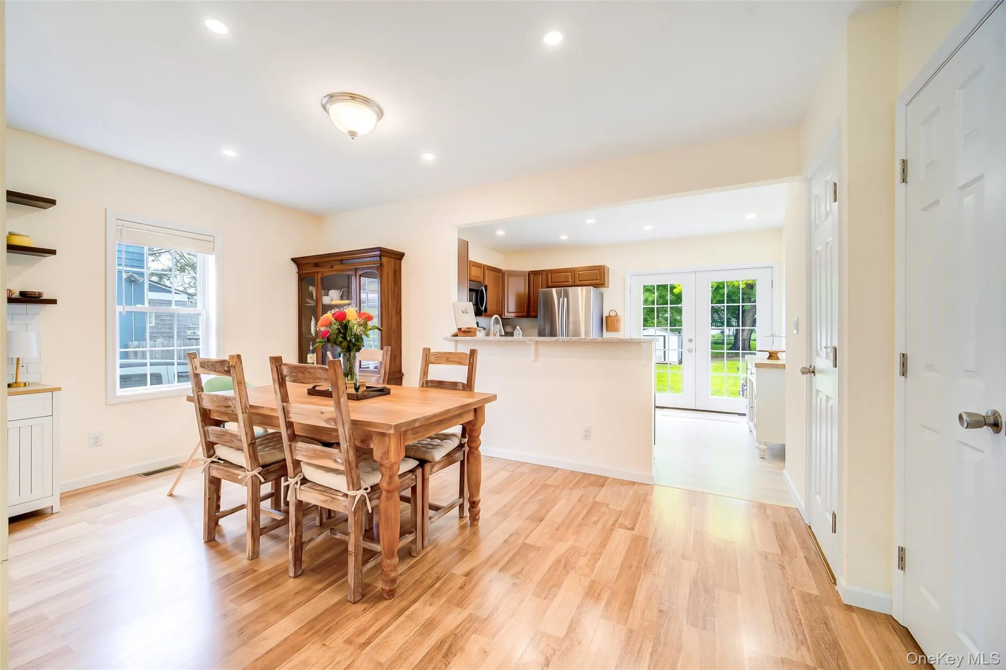 Open-concept dining area featuring wood-finish flooring, recessed lighting, and a window with natural light Open-concept dining area featuring wood-finish flooring, recessed lighting, and a window with natural light