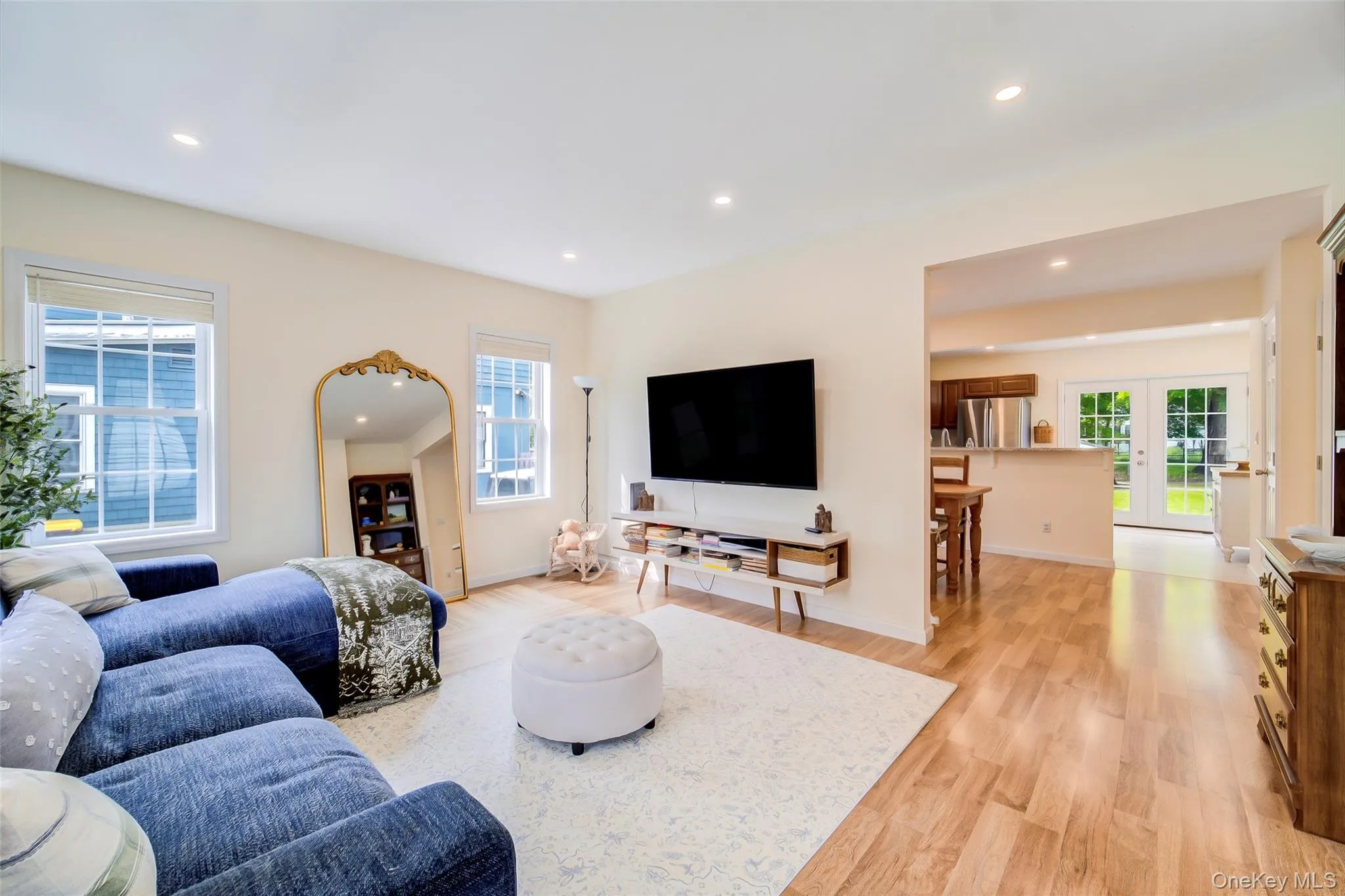 Open-concept living area featuring wood-finish flooring, recessed lighting, and a broad pass-through to the kitchen Open-concept living area featuring wood-finish flooring, recessed lighting, and a broad pass-through to the kitchen