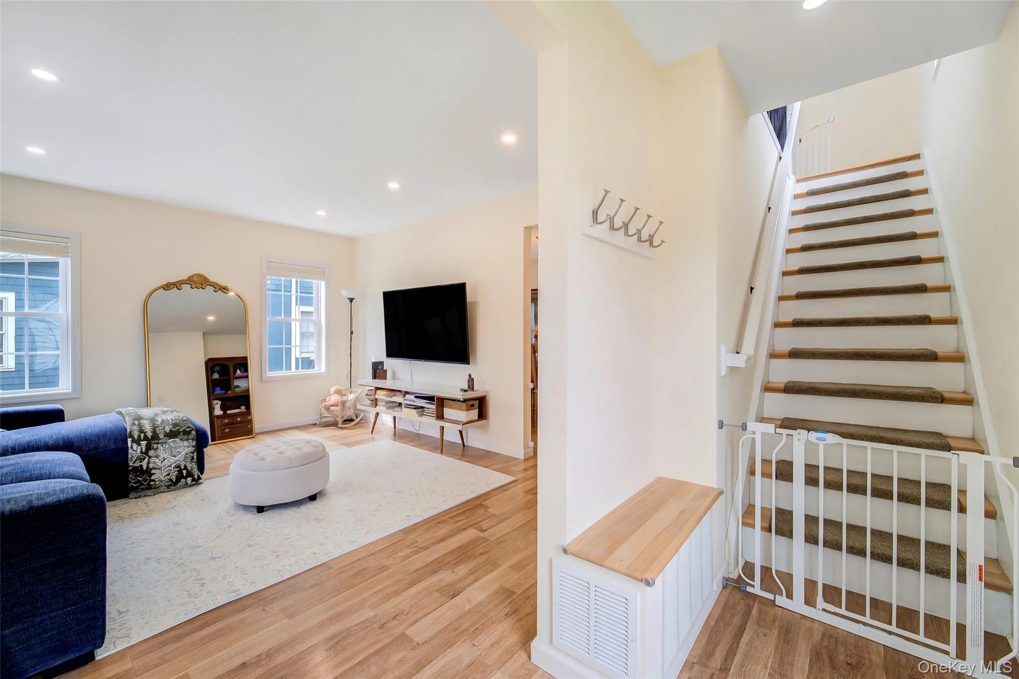 Bright living area featuring wood-finish flooring, recessed lighting, and multiple windows with white trim Bright living area featuring wood-finish flooring, recessed lighting, and multiple windows with white trim