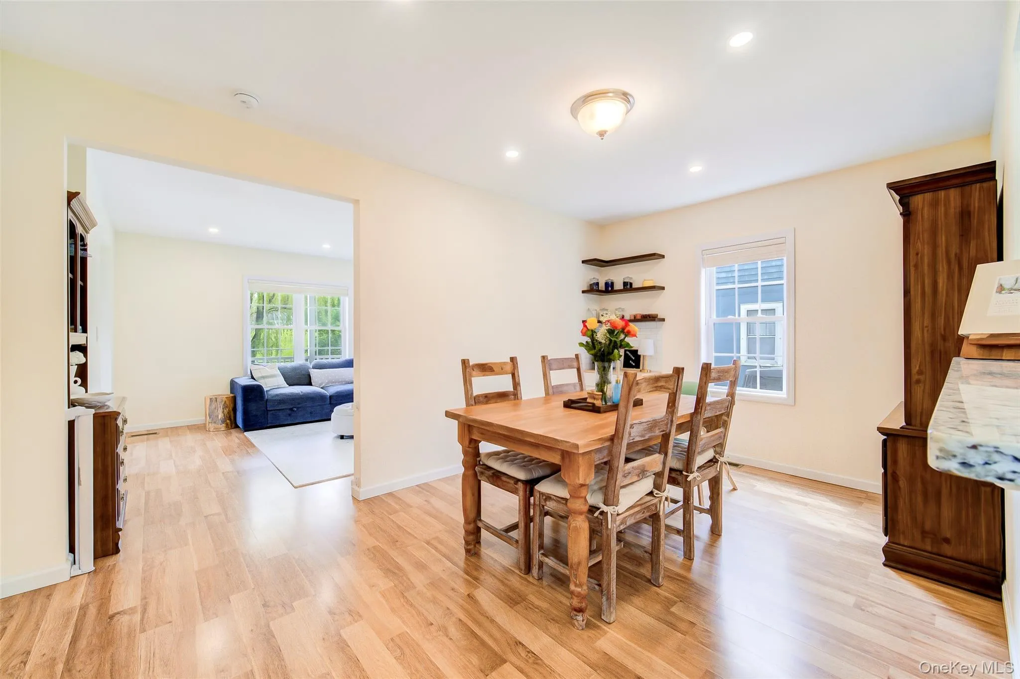 Dining area featuring light wood-finish flooring, recessed lighting, and a contemporary semi-flush mount fixture Dining area featuring light wood-finish flooring, recessed lighting, and a contemporary semi-flush mount fixture