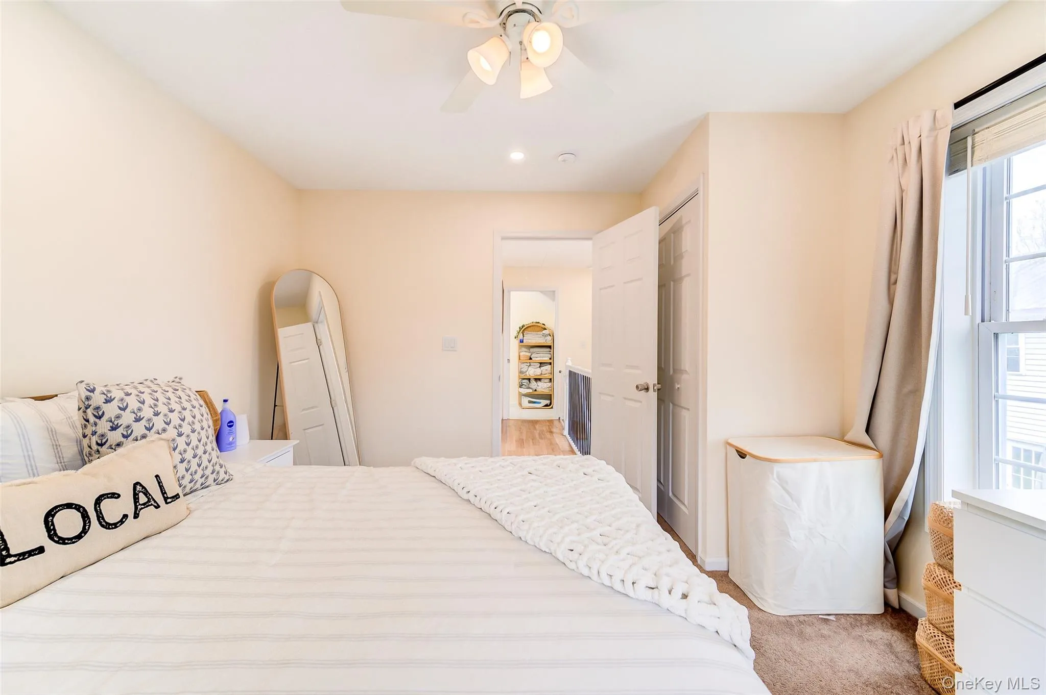 Carpeted master bedroom featuring an overhead ceiling fan, white trim, a window with natural light, and a white interior door Carpeted master bedroom featuring an overhead ceiling fan, white trim, a window with natural light, and a white interior door