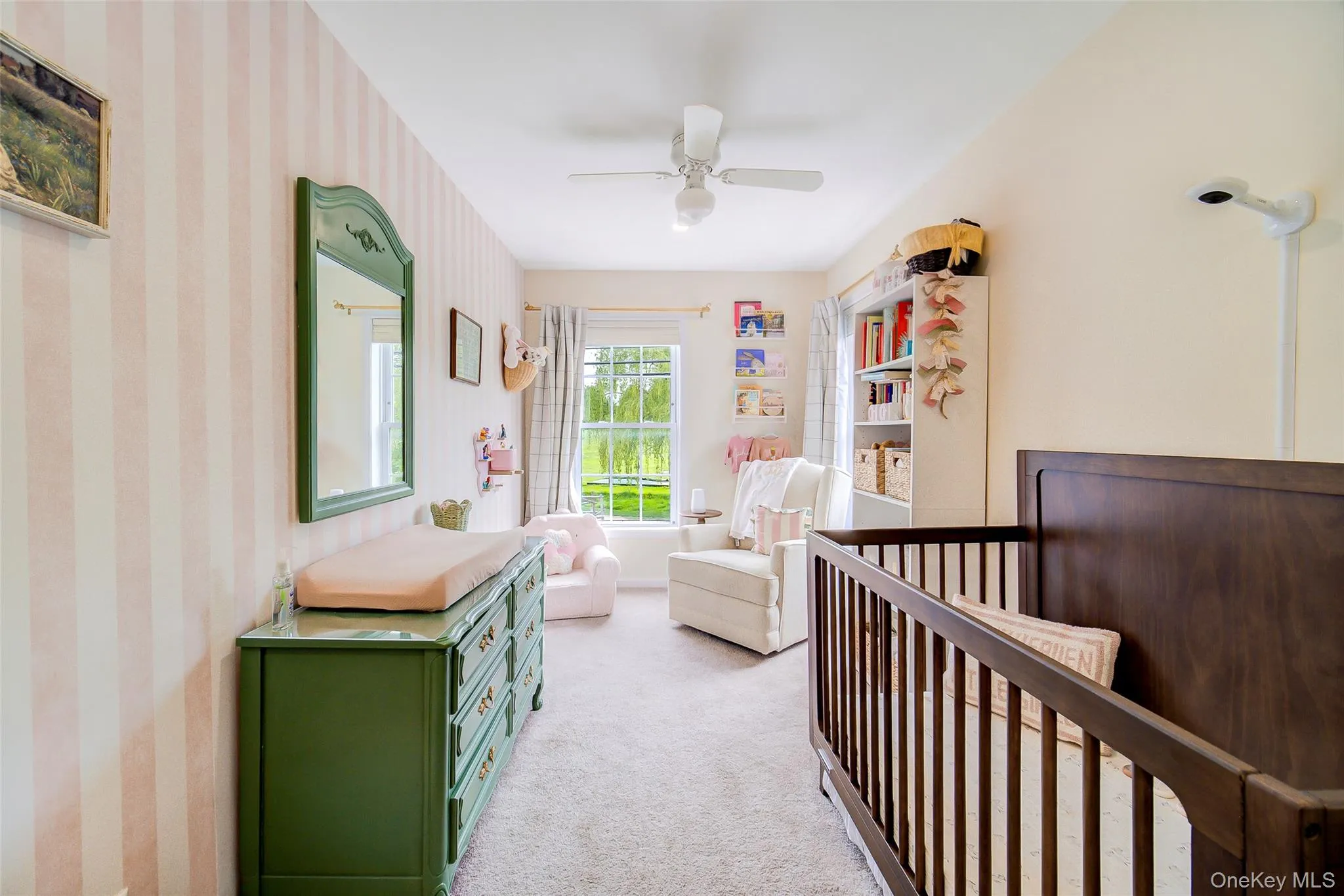 Spacious bedroom featuring carpet flooring, a ceiling fan, and a large window with natural light Spacious bedroom featuring carpet flooring, a ceiling fan, and a large window with natural light