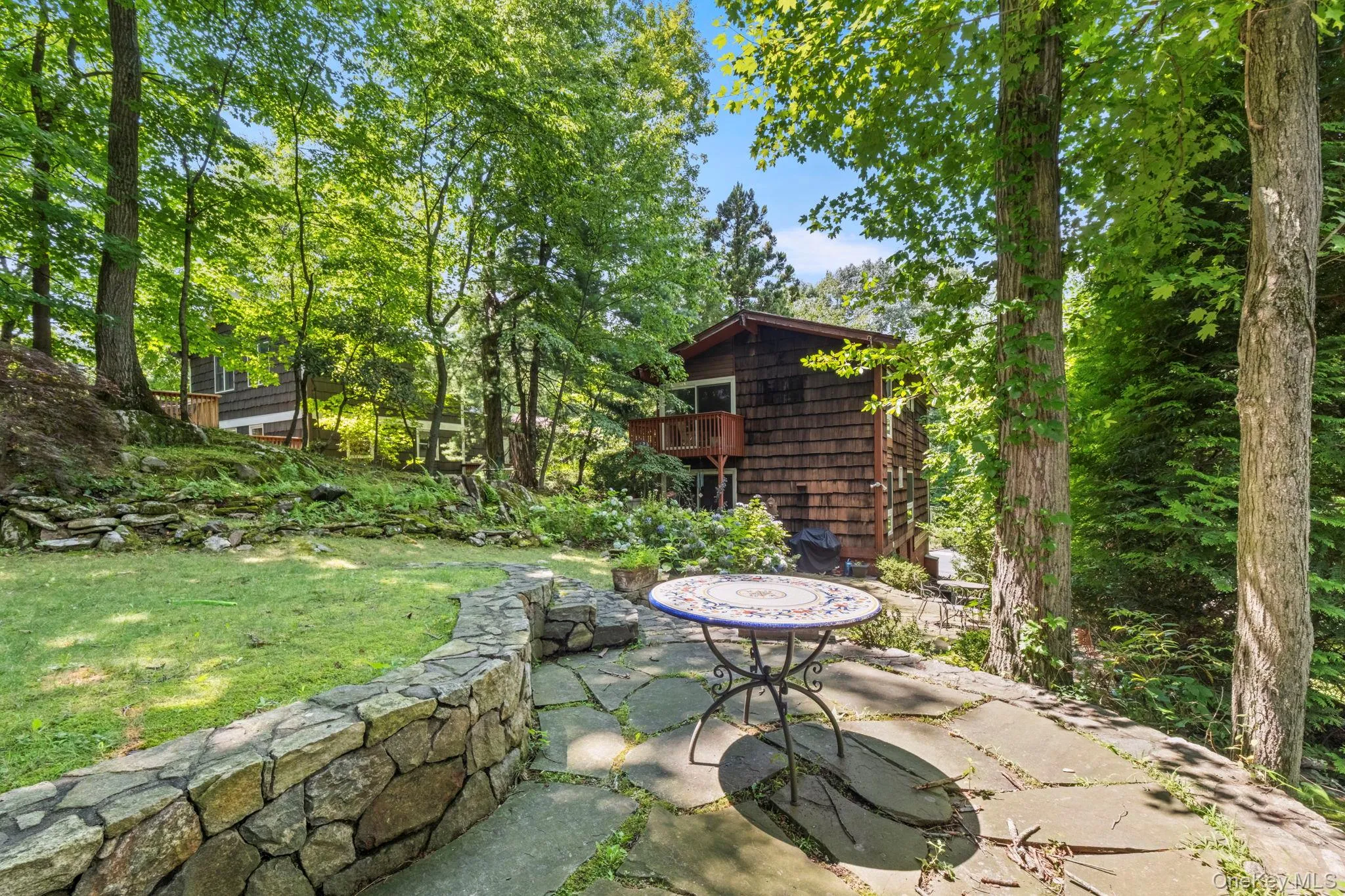 Flagstone patio with a stone retaining wall and lawn large enough for a play set Flagstone patio with a stone retaining wall and lawn large enough for a play set