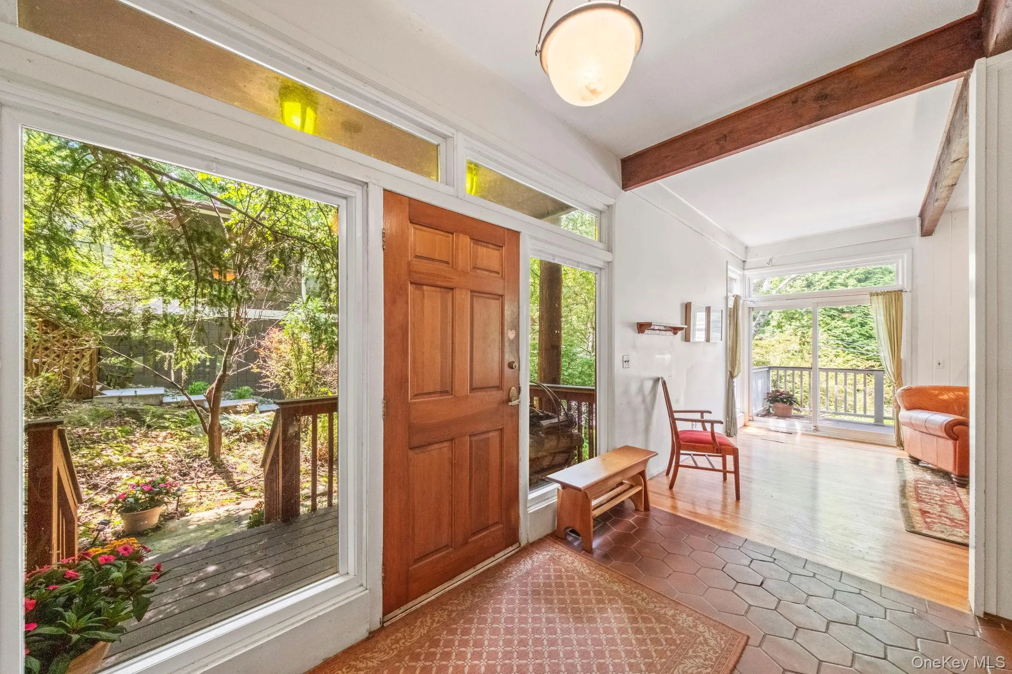 Entryway featuring a wood-panel door, transom windows, and a tiled floor Entryway featuring a wood-panel door, transom windows, and a tiled floor