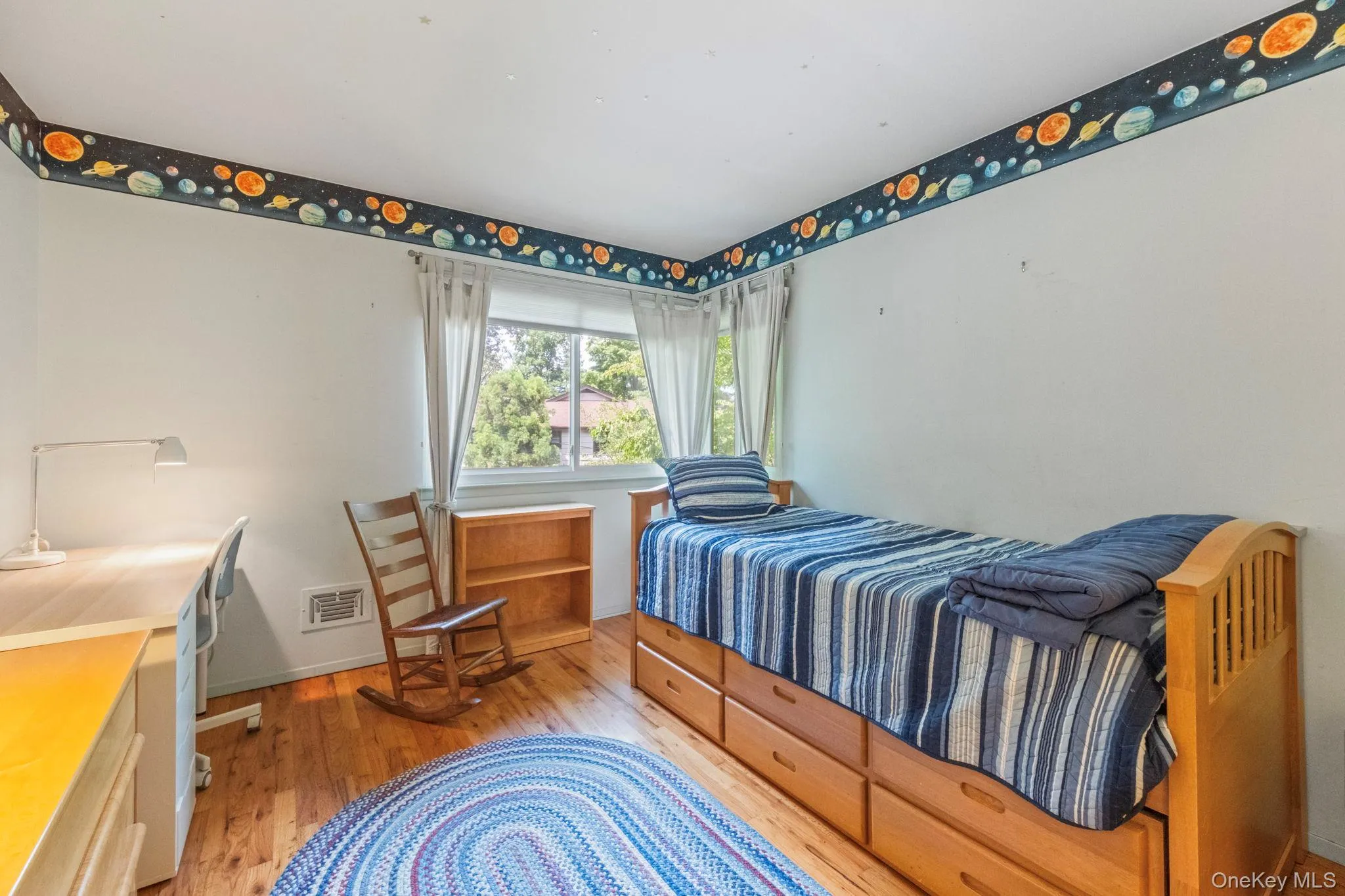 Hardwood flooring complements a light blue interior featuring a corner window Hardwood flooring complements a light blue interior featuring a corner window