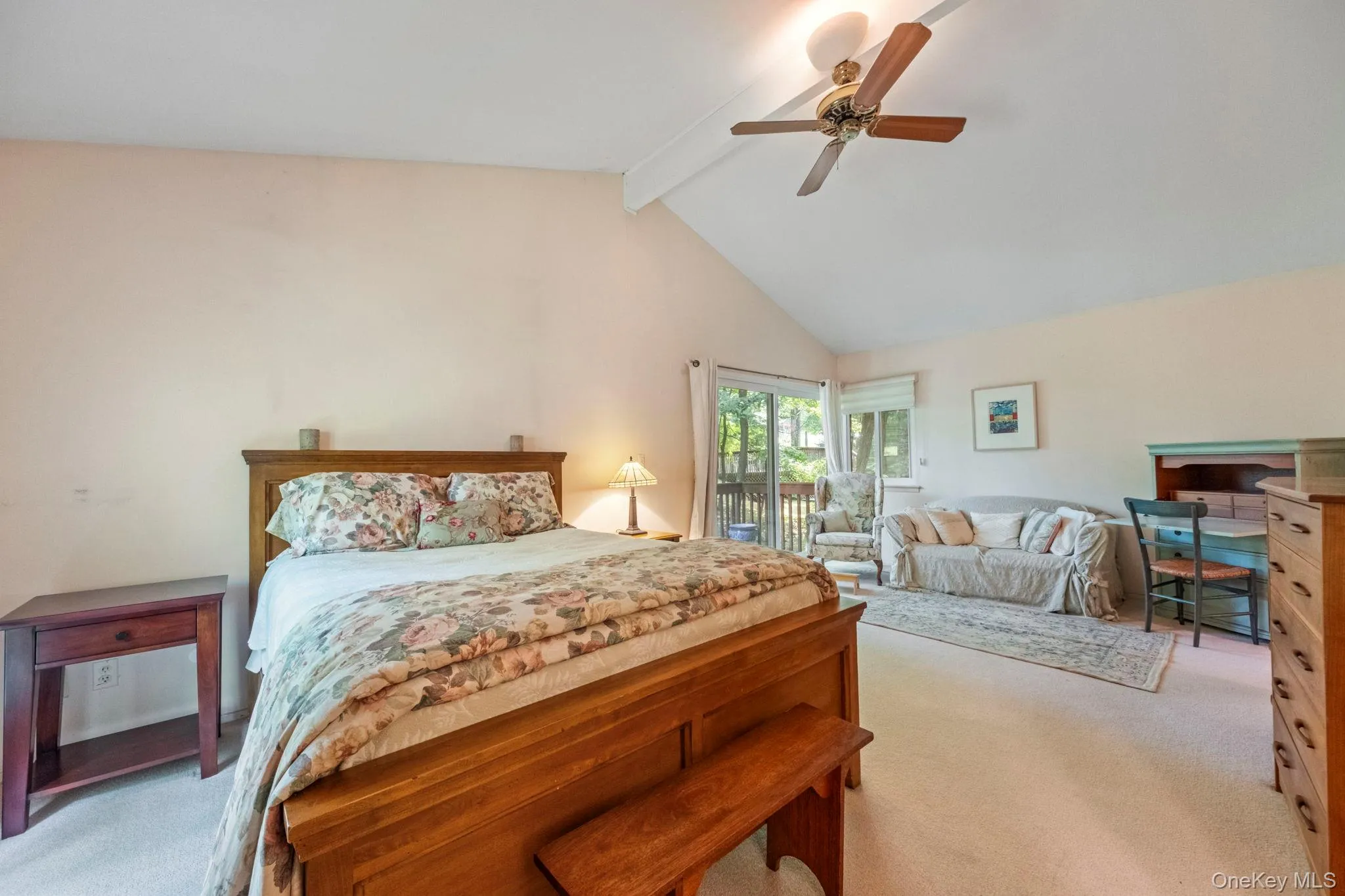 Vaulted ceiling bedroom featuring carpet flooring and a ceiling fan Vaulted ceiling bedroom featuring carpet flooring and a ceiling fan