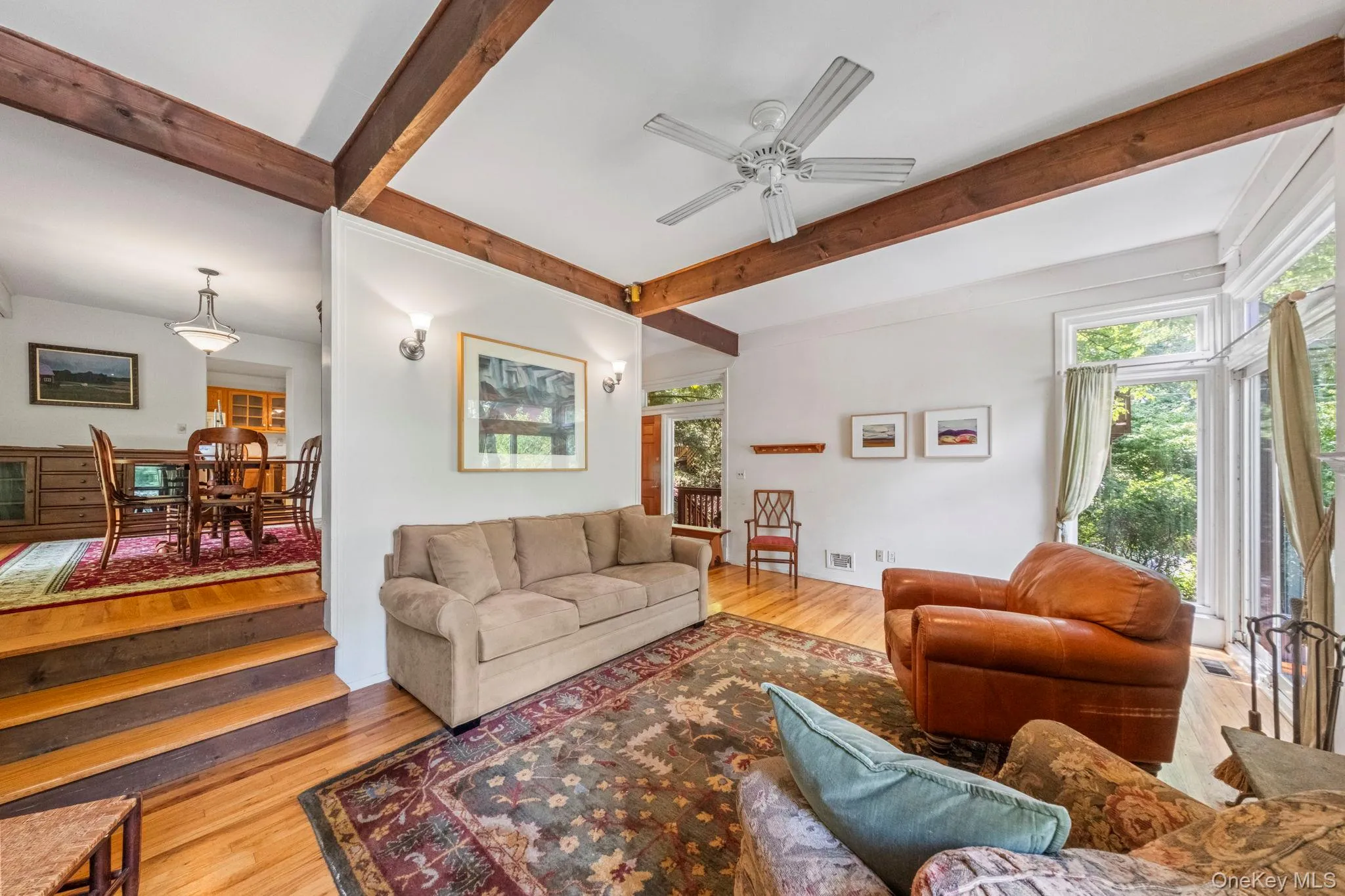 Hardwood flooring with exposed ceiling beams and a white ceiling fan Hardwood flooring with exposed ceiling beams and a white ceiling fan